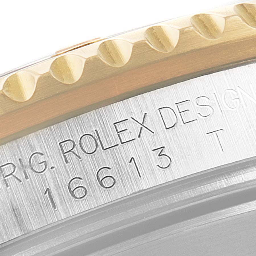 Close-up of the case showing the "ROLEX DESIGN 16613" engraving on a Rolex Submariner 16613 Men's Steel and Gold (two tone) Blue Dial 16613 Men's Steel and Gold (two tone) Blue Dial model.