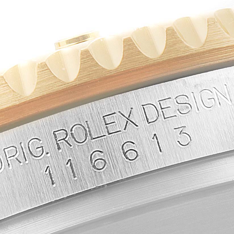 This close-up image shows the engraved reference number and part of the bezel of a Rolex Submariner 116613 Men's Steel and Gold (two tone) Blue Dial 116613 Men's Steel and Gold (two tone) Blue Dial watch.
