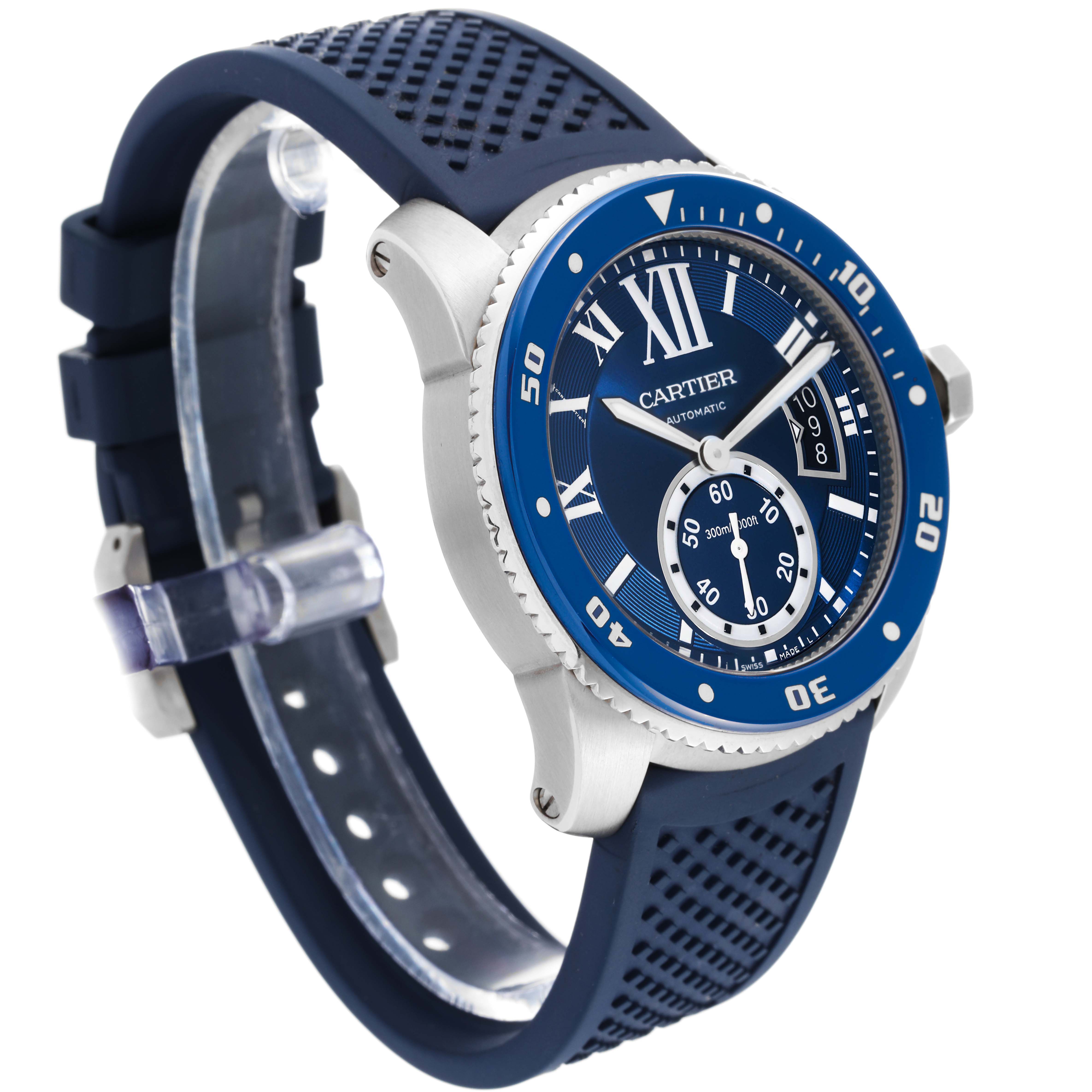 The image shows a Calibre de Cartier watch by Cartier at an angled view, highlighting its blue bezel, dial, and rubber strap.