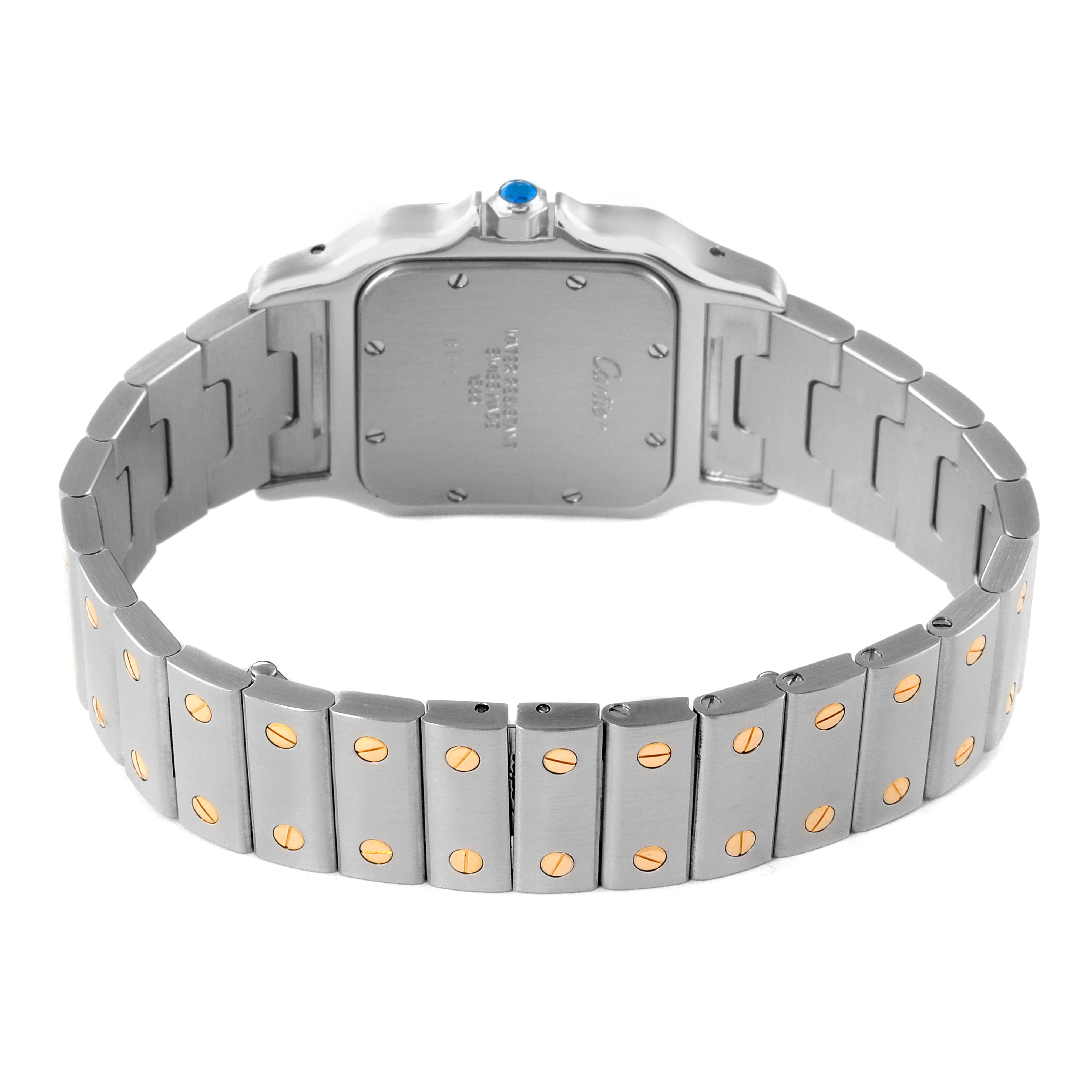 The image shows the Santos model watch by Cartier from the back, highlighting its stainless steel bracelet with gold screw accents.
