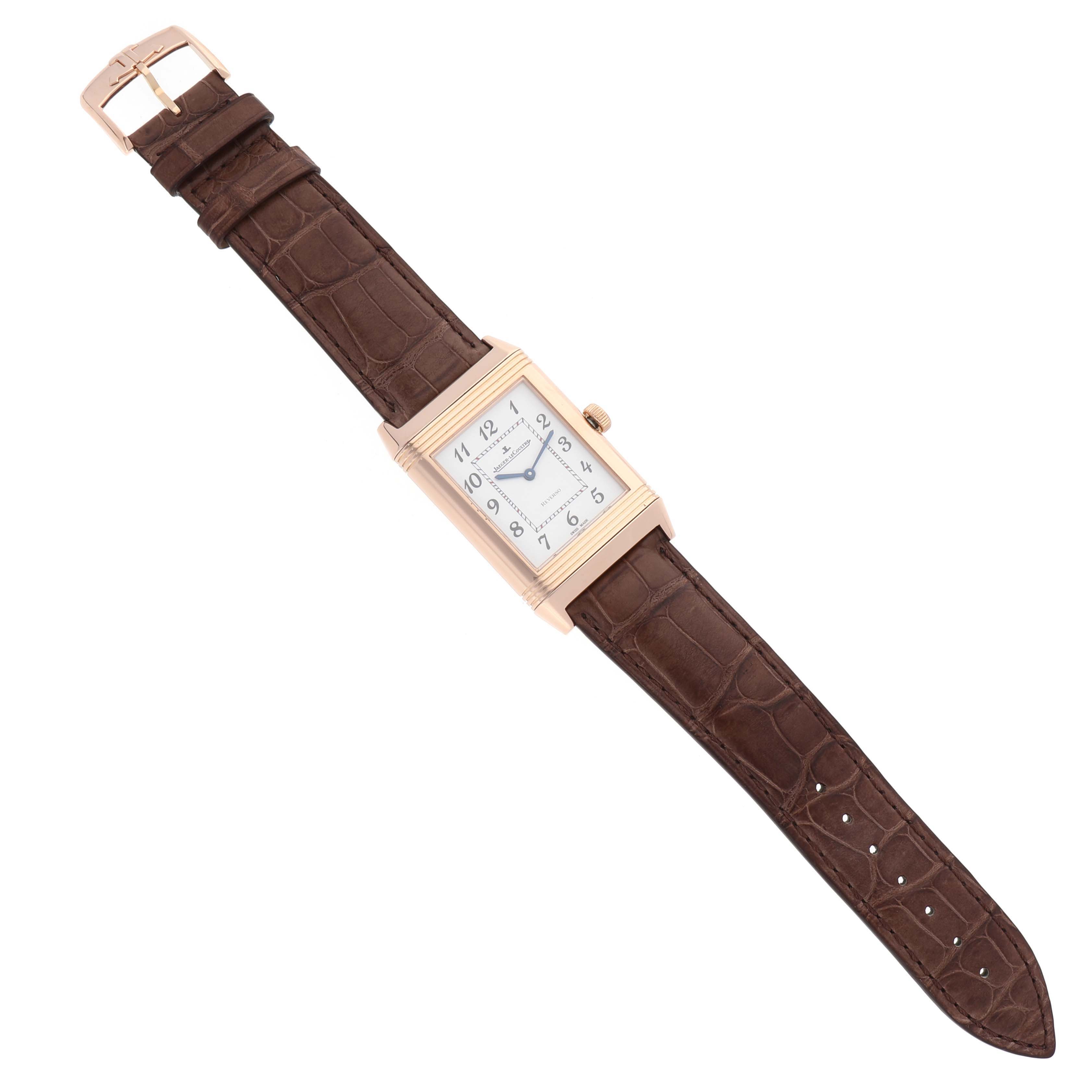 The Jaeger LeCoultre Reverso Q3732523 Men's Rose Gold White Dial Q3732523 Men's Rose Gold White Dial model watch is shown from a top-down angle, displaying the face, rectangular case, and brown leather strap.