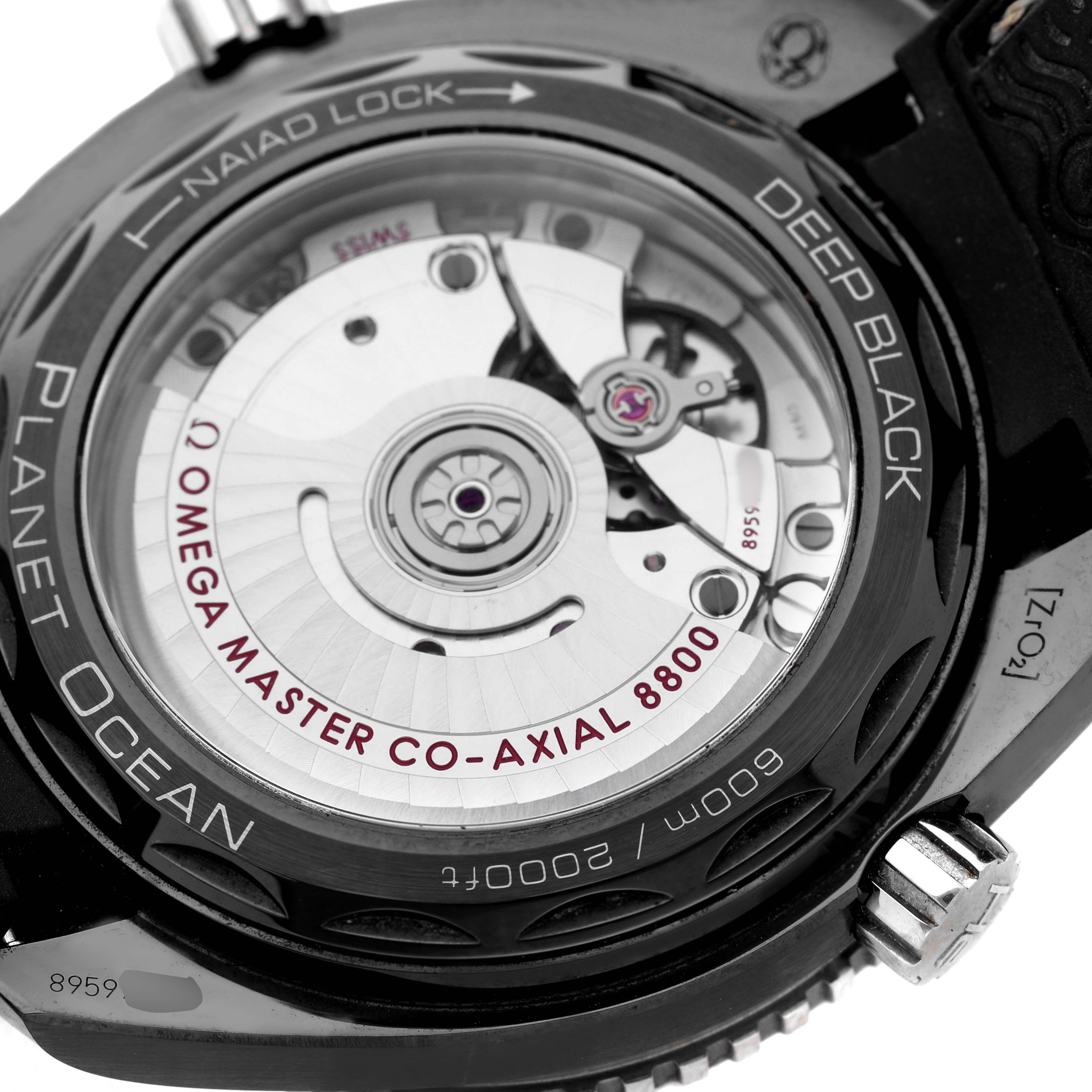 The image shows the case back of the Omega Planet Ocean 215.92.40.20.01.001 Men's Ceramic Black Dial, highlighting the movement and inscriptions.
