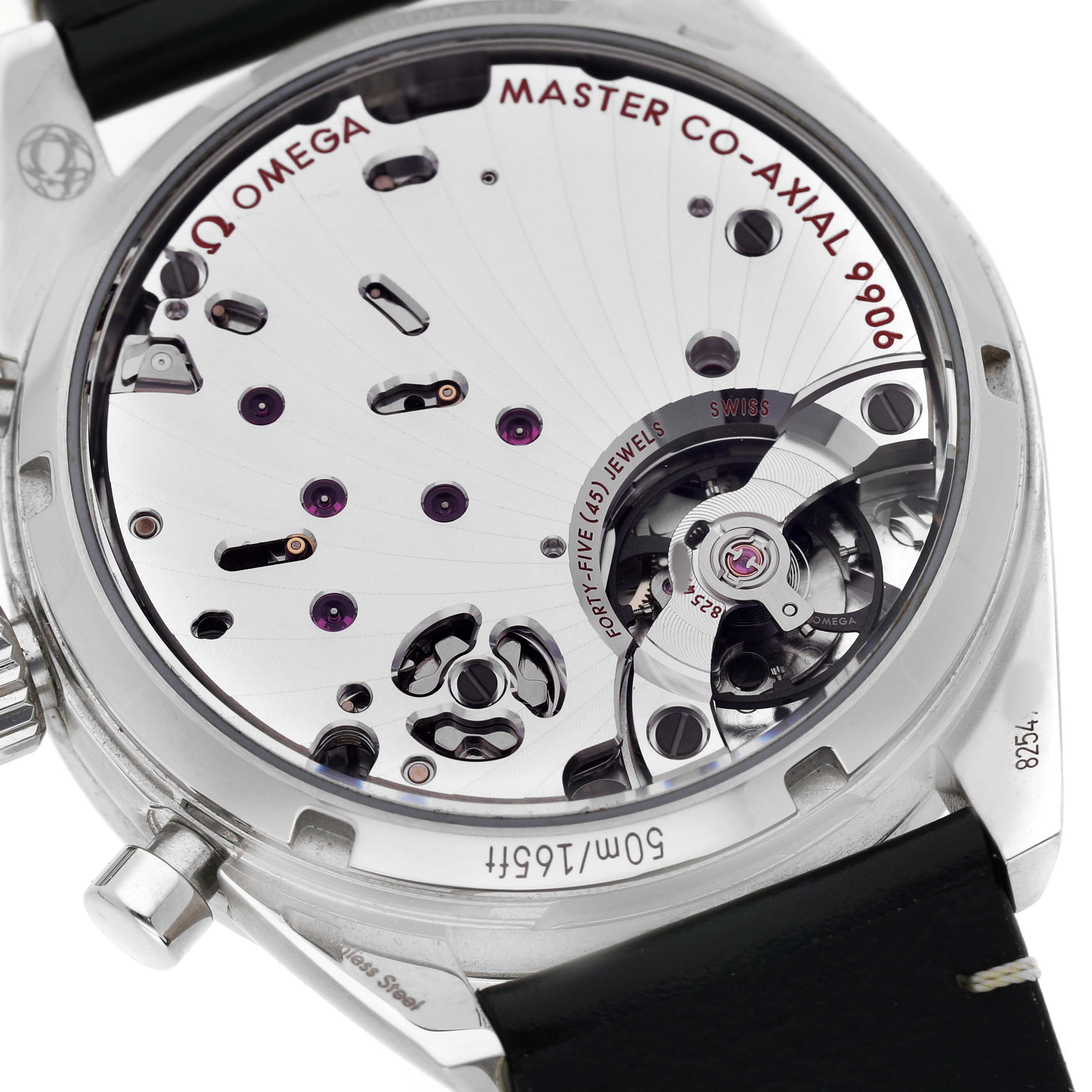 The image shows the back of an Omega Speedmaster 332.12.41.51.10.001 Men's Stainless Steel Green Dial, featuring the movement with visible jewels and the "Master Co-Axial 9906" inscription.