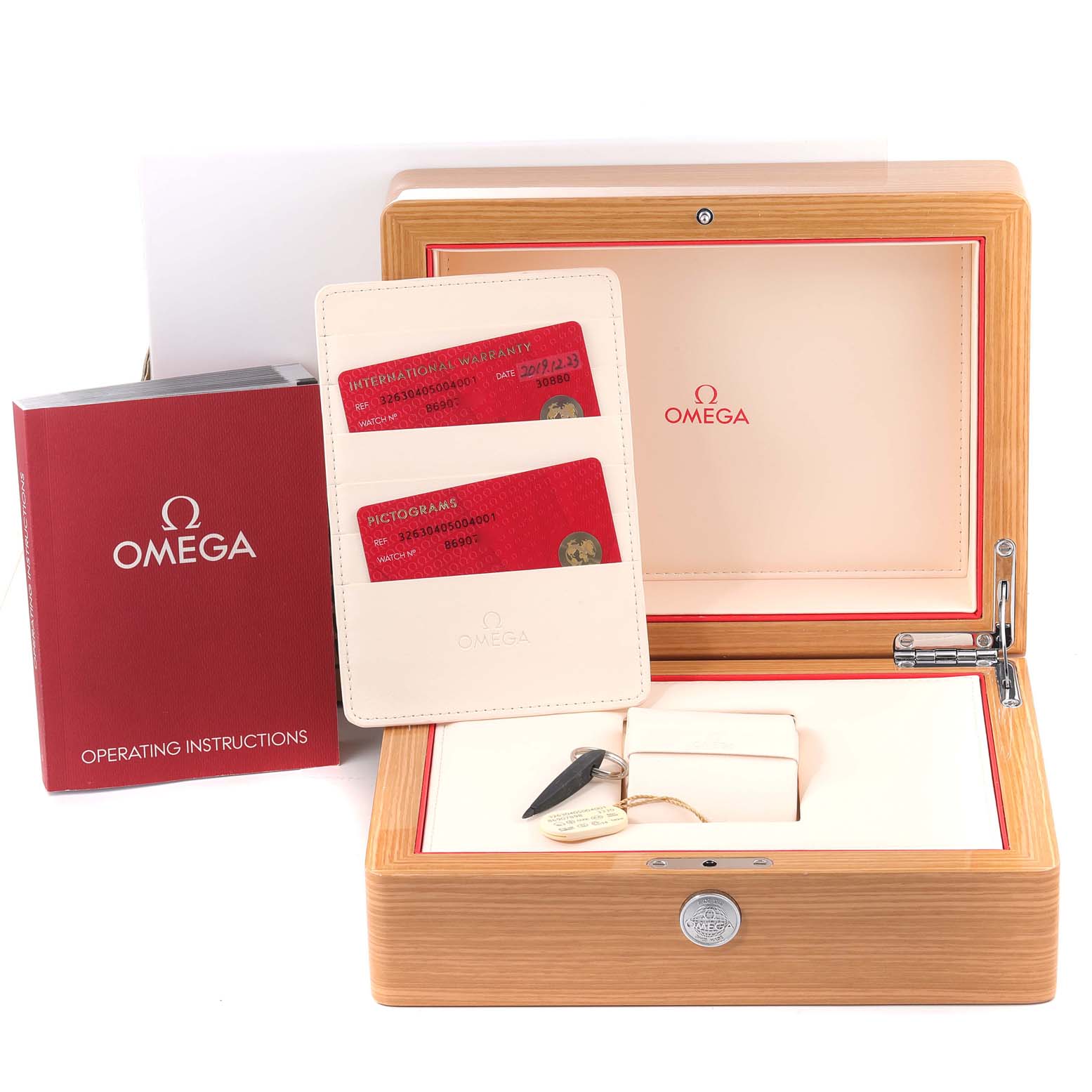 The image shows the Omega Speedmaster 326.30.40.50.04.001 Men's Stainless Steel White Dial 326.30.40.50.04.001 Men's Stainless Steel White Dial watch's wooden box, operating instructions, warranty cards, and a key.