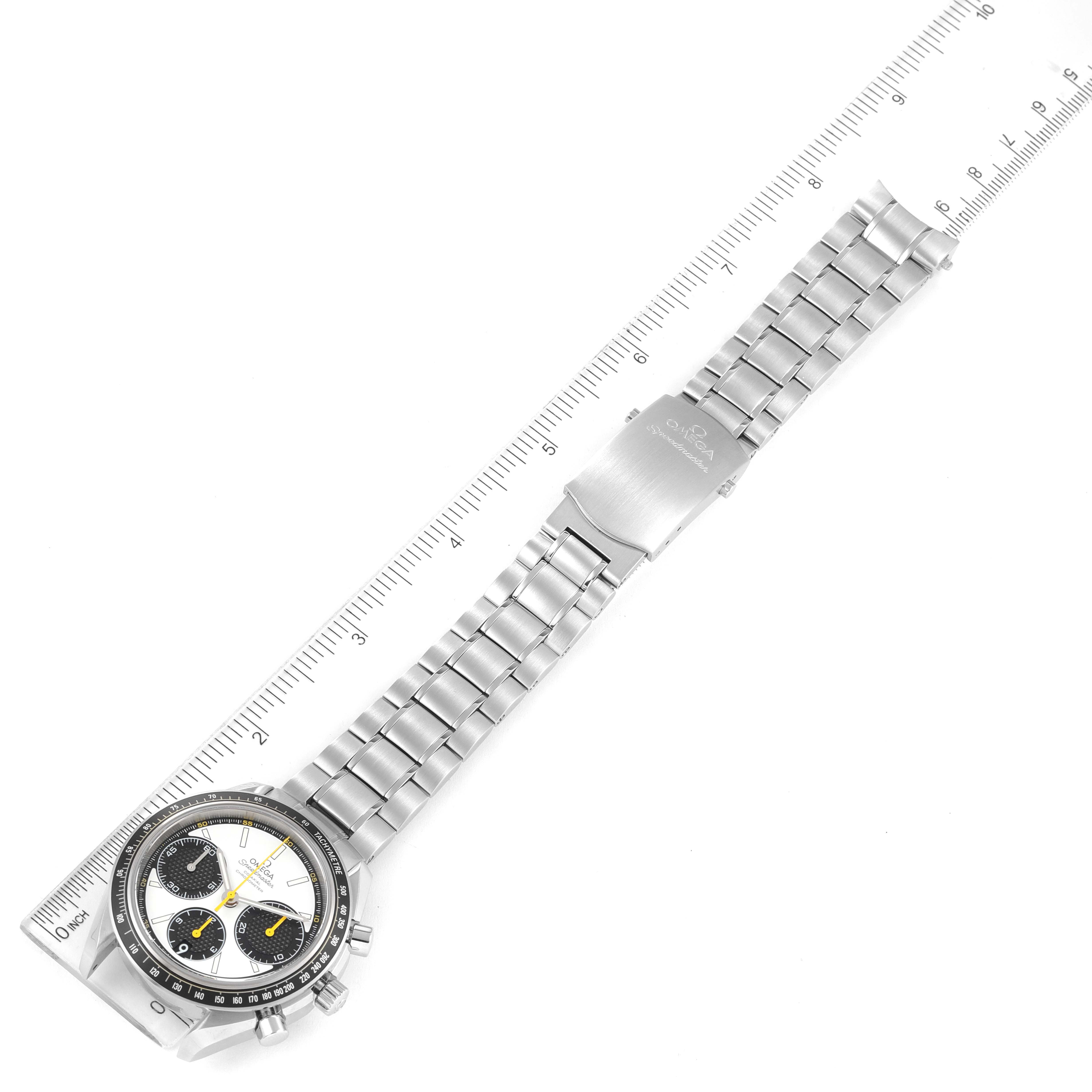 The Omega Speedmaster 326.30.40.50.04.001 Men's Stainless Steel White Dial 326.30.40.50.04.001 Men's Stainless Steel White Dial watch is shown at an angle revealing its face, bezel, and stainless steel bracelet placed alongside a ruler.