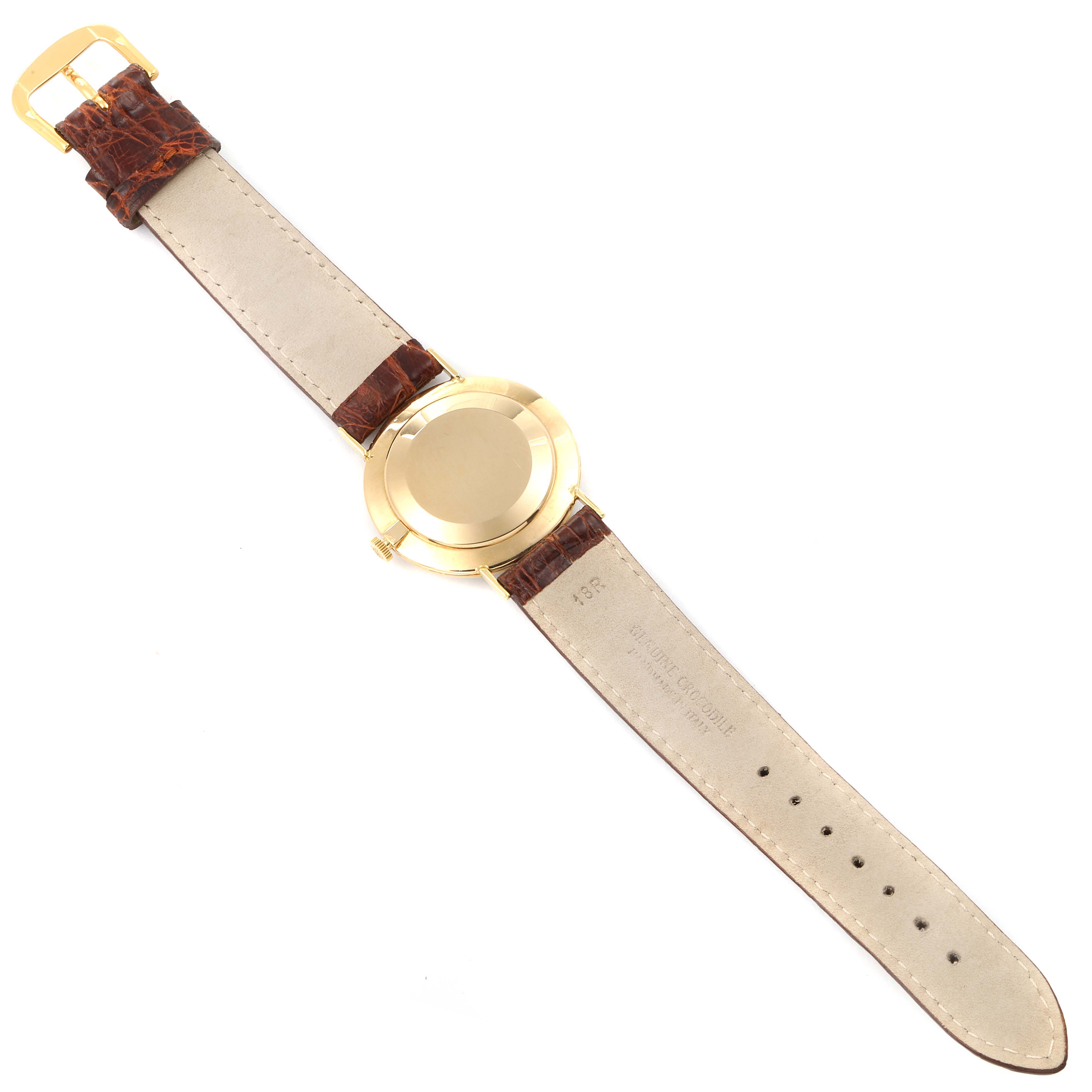 The image shows the back view of a Vintage Patek Philippe watch, highlighting its gold case and brown leather strap.