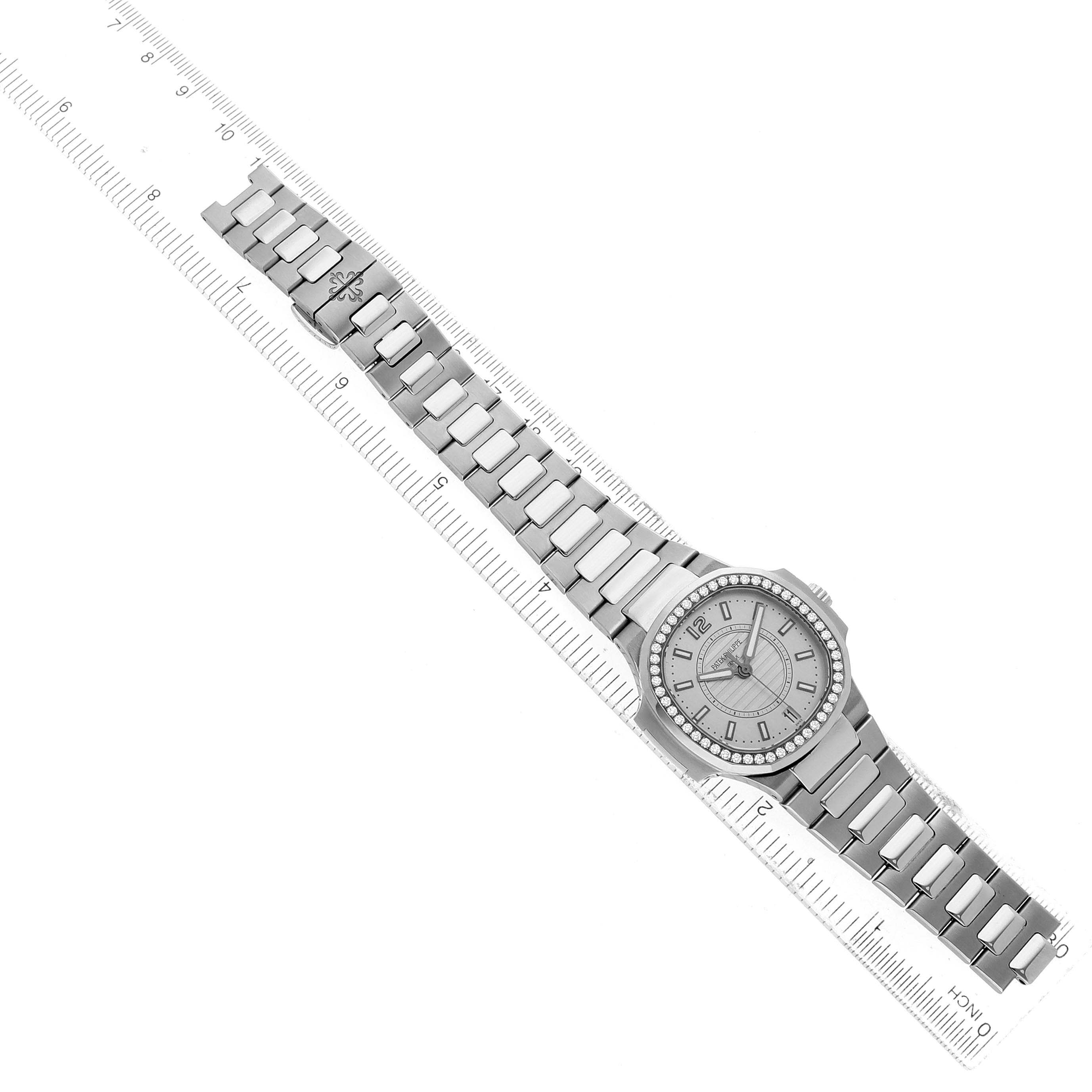 The Patek Philippe Nautilus 7008/1A-011 Women's Stainless Steel Silver Dial watch is shown from a top-down angle, highlighting its face and metal bracelet alongside a ruler.