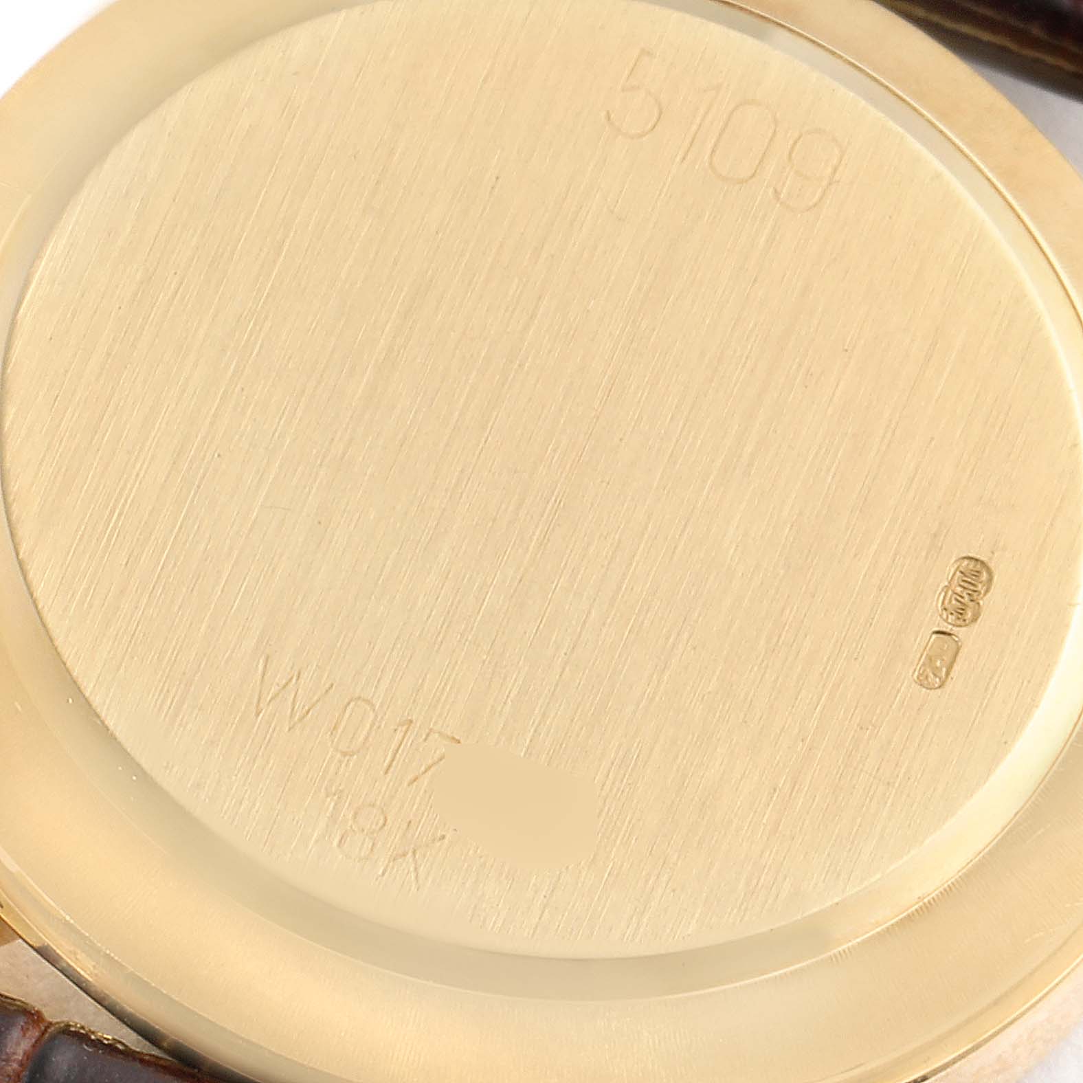 The image shows the back case of a Rolex Cellini 5109 Women's Yellow Gold White Dial 5109 Women's Yellow Gold White Dial watch, featuring engravings of the model number and material.