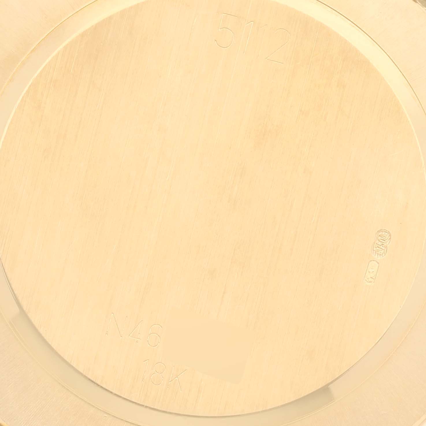 This image shows the back casing of a Rolex Cellini 5112 Men
s Yellow Gold Champagne Dial 5112 Men
s Yellow Gold Champagne Dial watch in 18K gold, displaying engravings and hallmarks.