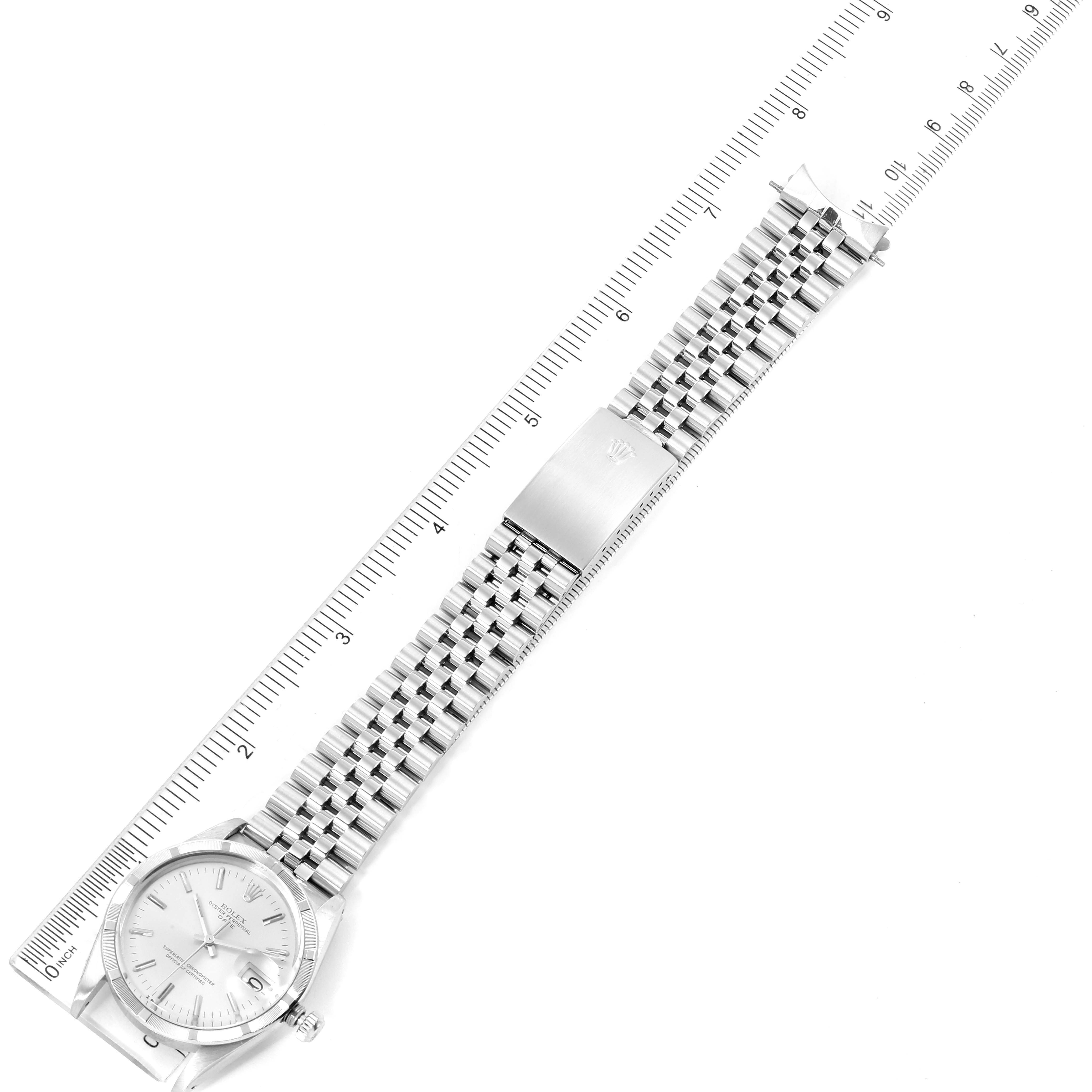 The image shows the Rolex Vintage Collection 15010 Men's Stainless Steel Silver Dial 15010 Men's Stainless Steel Silver Dial watch laid flat, displaying its face, bracelet, and clasp, next to a ruler.