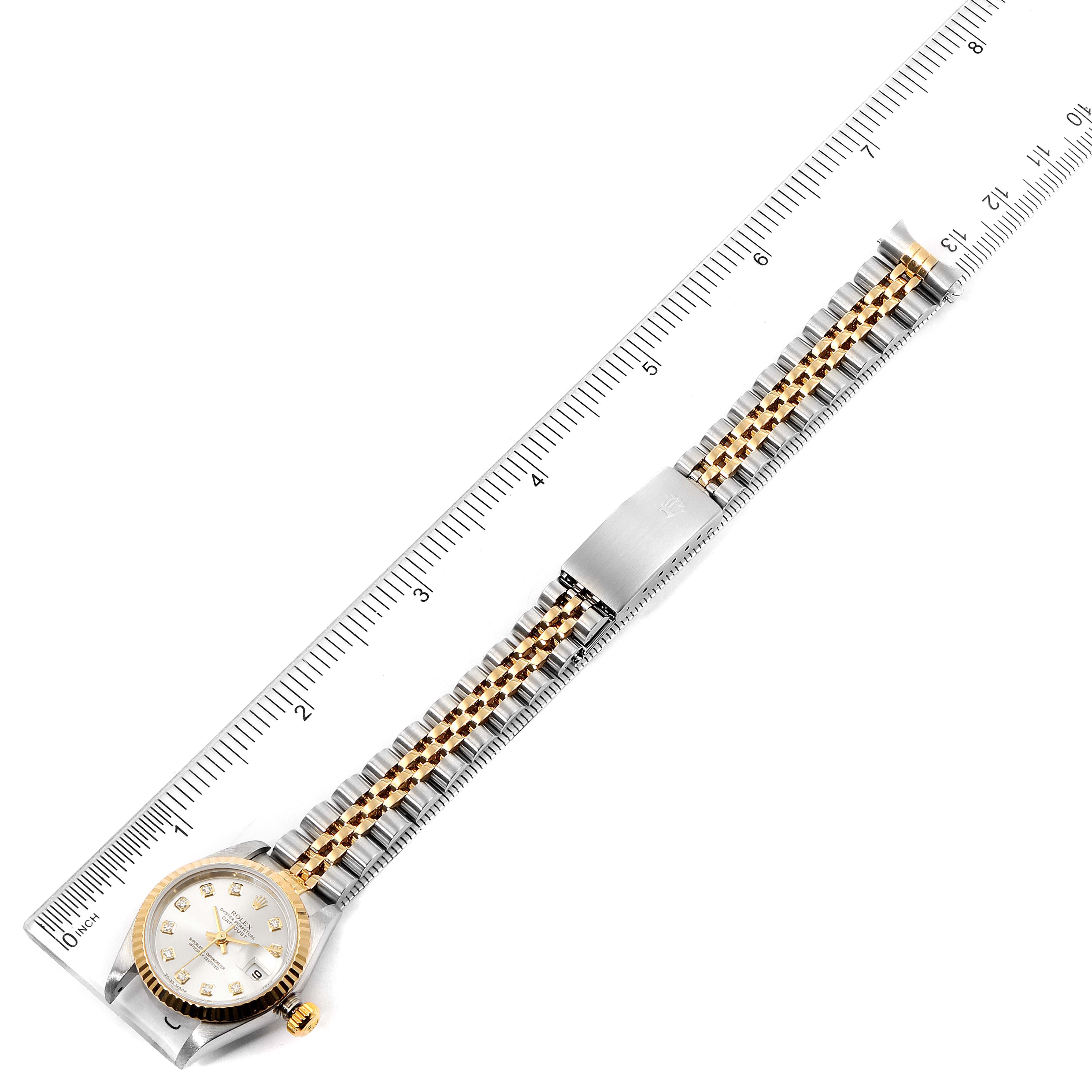 The image shows a Rolex Datejust 79173 Women's Steel and Gold (two tone) Silver Dial 79173 Women's Steel and Gold (two tone) Silver Dial watch laid flat beside a ruler, displaying the bracelet and dial from an overhead view.