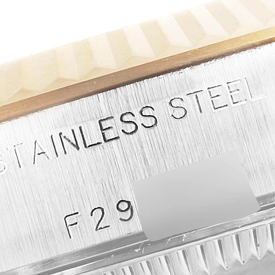 This close-up image shows the engraved side of a Rolex Datejust 79173 Women's Steel and Gold (two tone) Silver Dial 79173 Women's Steel and Gold (two tone) Silver Dial watch, focusing on the stainless steel text and part of the fluted bezel.