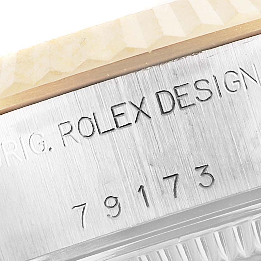 The image shows a close-up of the serial number and "ROLEX DESIGN" engraving on the side of a Rolex Datejust 79173 Women's Steel and Gold (two tone) Silver Dial 79173 Women's Steel and Gold (two tone) Silver Dial watch case.