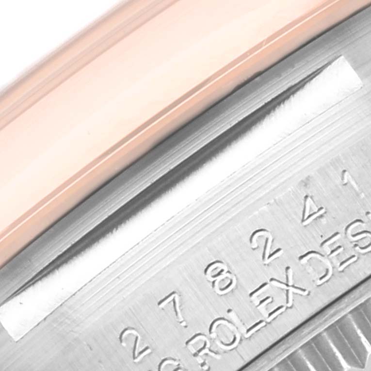 The image shows a close-up of the bezel and part of the engraved inner case of a Mid-Size Rolex watch.