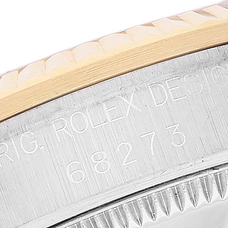 The image shows a close-up of the case edge and bezel of a Mid-Size Rolex watch, revealing engravings and serrations.