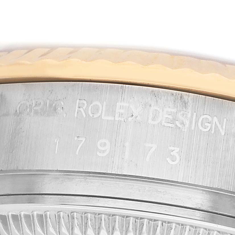 The image shows a close-up of the side of a Rolex Datejust 179173 Women's Steel and Gold (two tone) Mother of Pearl Dial, focusing on the engraved bezel and part of the case.