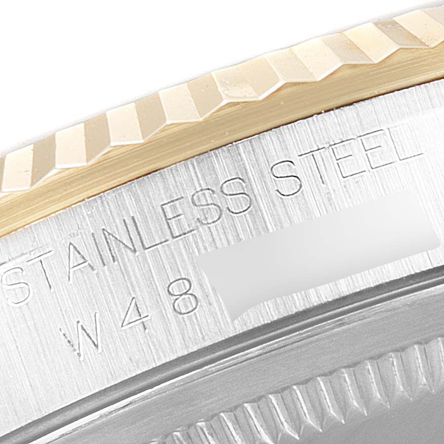 This close-up angle shows part of the fluted bezel and serial number engraving on a Rolex Datejust 16233 Men's Steel and Gold (two tone) Blue Dial 16233 Men's Steel and Gold (two tone) Blue Dial model.