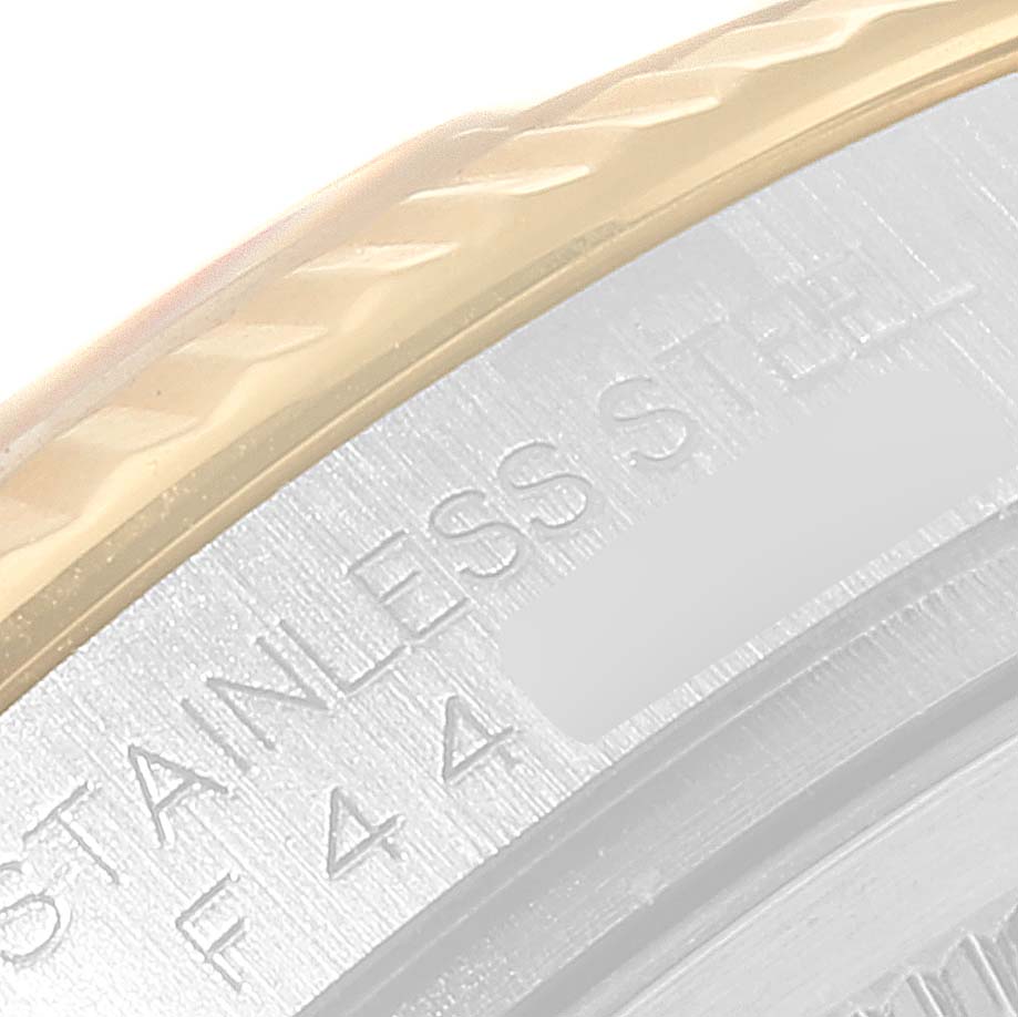 This image shows a close-up of the bezel and part of the case back of a Rolex Datejust 116233 Men's Steel and Gold (two tone) Black Dial 116233 Men's Steel and Gold (two tone) Black Dial model.