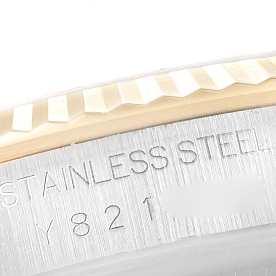 This close-up shows the fluted bezel and part of the casing with the engraved text of a Rolex Datejust 16233 Men's Steel and Gold (two tone) Black Dial 16233 Men's Steel and Gold (two tone) Black Dial watch.