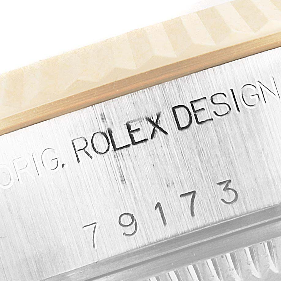This close-up image shows the engraved serial number and "Rolex Design" text on the side of a Rolex Datejust 79173 Women's Steel and Gold (two tone) Champagne Dial 79173 Women's Steel and Gold (two tone) Champagne Dial watch case.