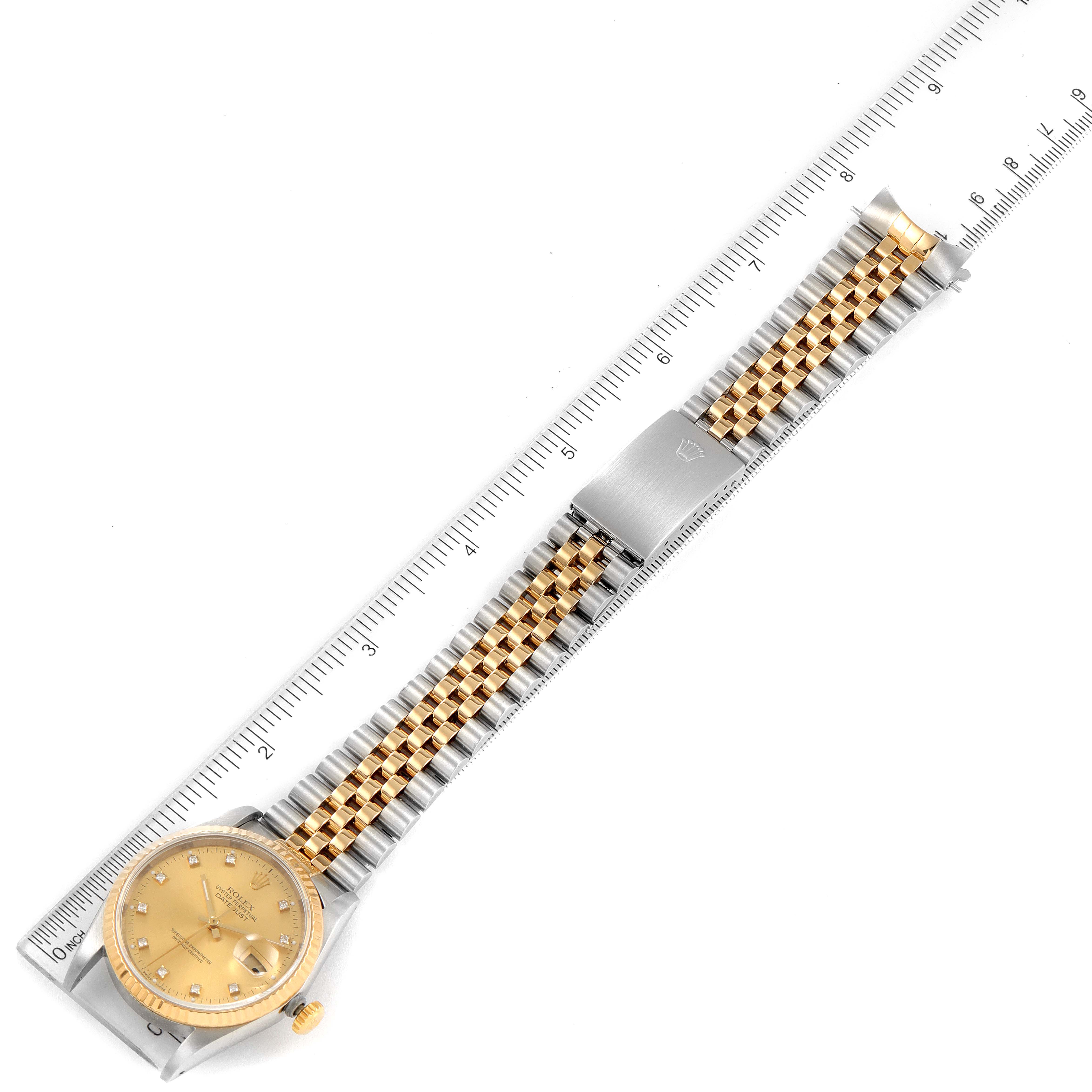 This image shows a Rolex Datejust 16233 Men
s Steel and Gold (two tone) Champagne Dial 16233 Men
s Steel and Gold (two tone) Champagne Dial model watch placed flat, highlighting its dial, crown, and two-tone bracelet, measured against a ruler.