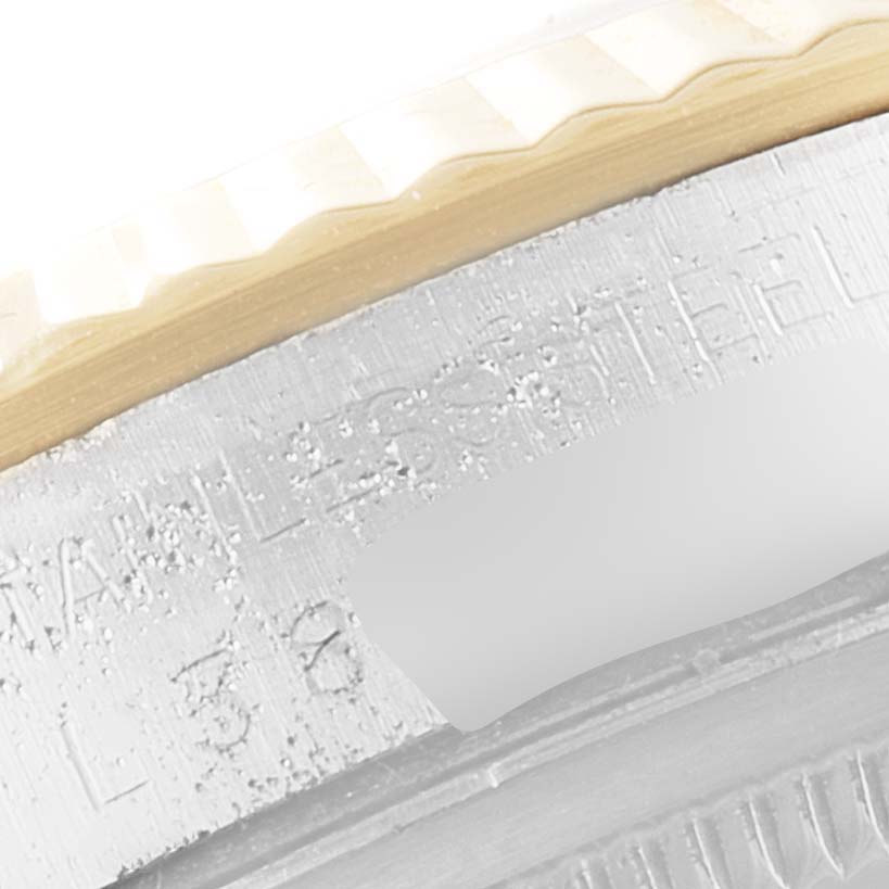 The image shows a close-up of the fluted bezel and part of the case engraving on a Rolex Datejust 16233 Men
s Steel and Gold (two tone) Champagne Dial 16233 Men
s Steel and Gold (two tone) Champagne Dial.