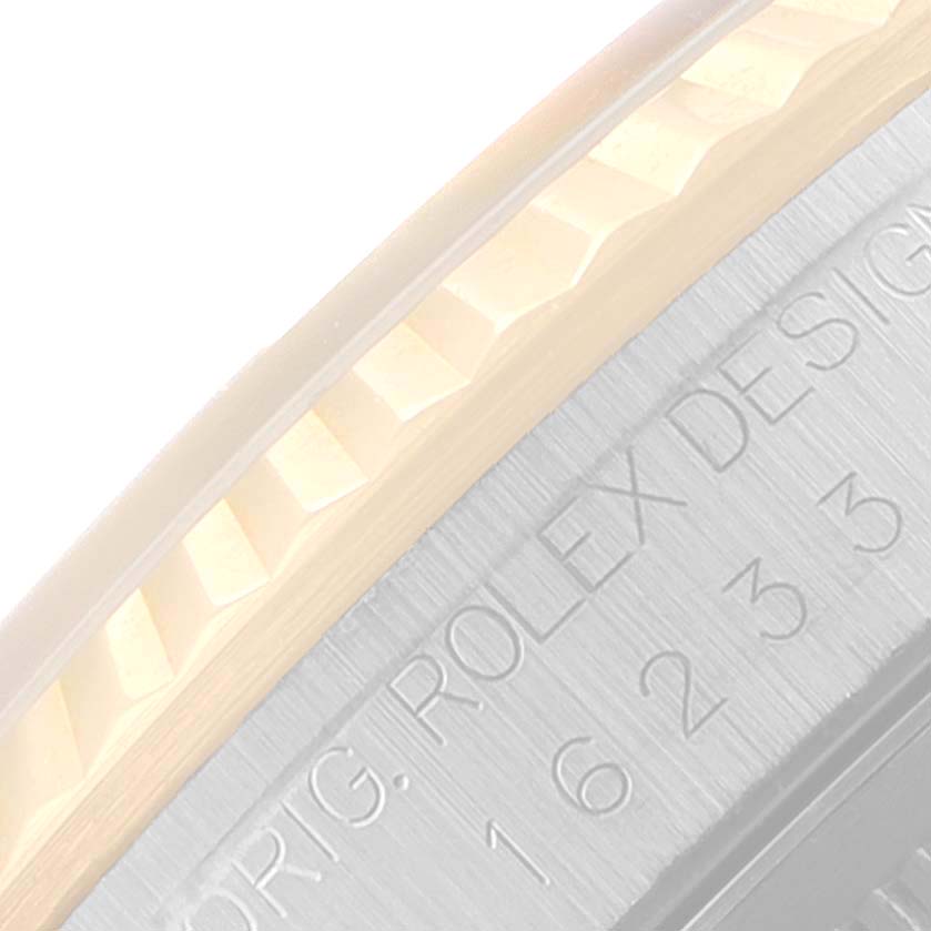The image shows a close-up of the fluted bezel and the engraved side of the case of a Datejust model by Rolex.