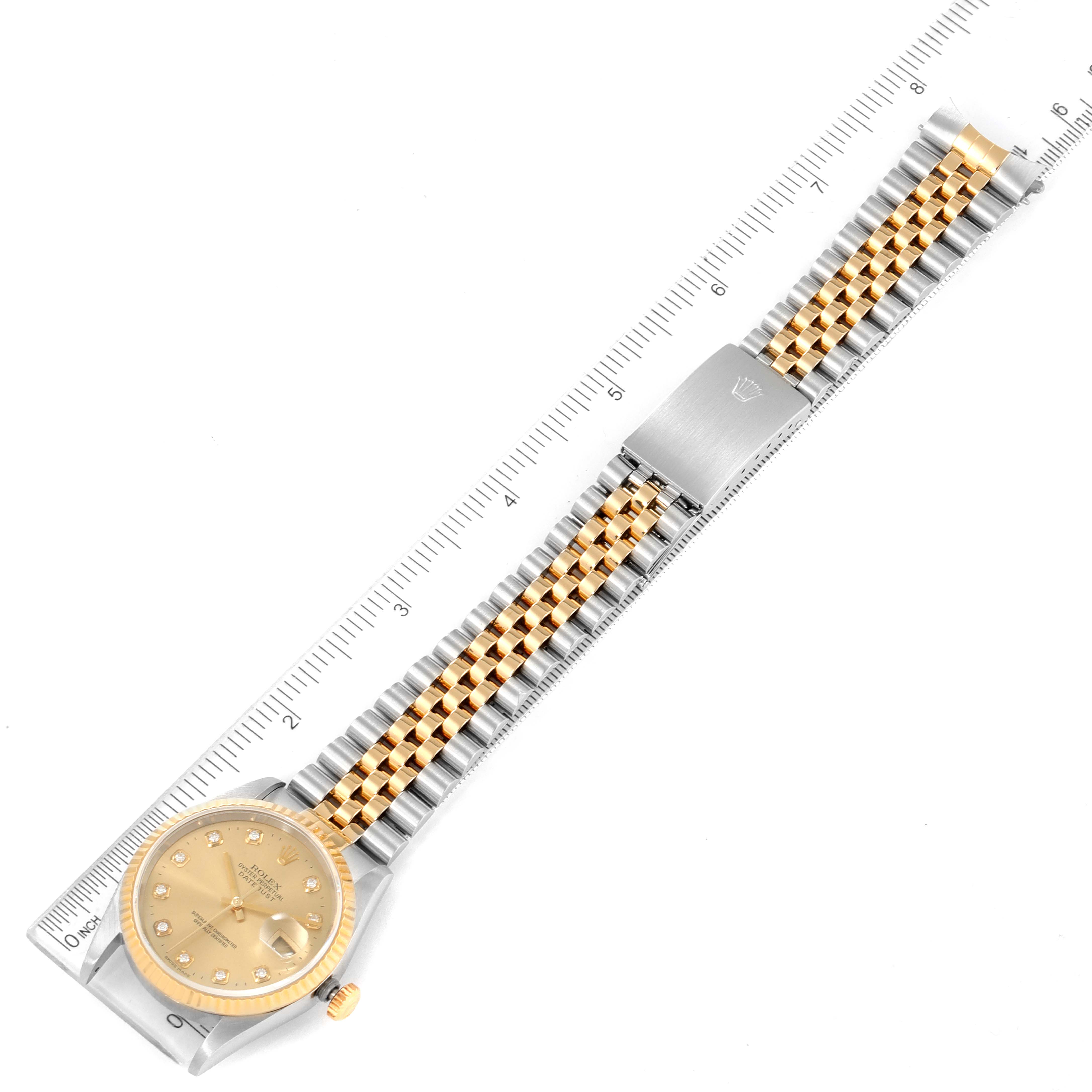 The image shows a top-down view of a Rolex Datejust 16233 Men's Steel and Gold (two tone) Champagne Dial 16233 Men's Steel and Gold (two tone) Champagne Dial watch with a two-tone metal bracelet, ruler for scale.