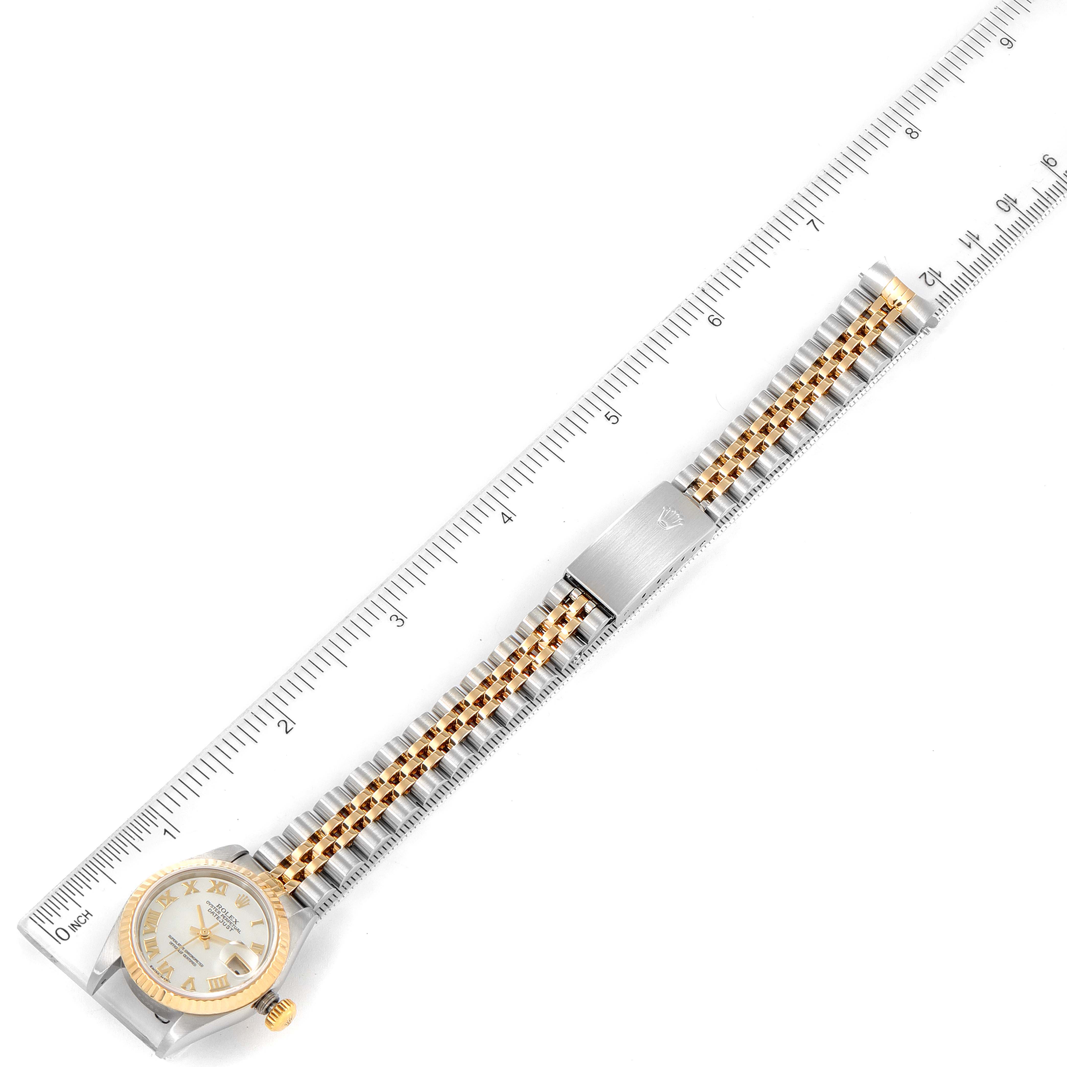 The Rolex Datejust 79173 Women
s Steel and Gold (two tone) Mother of Pearl Dial 79173 Women
s Steel and Gold (two tone) Mother of Pearl Dial watch is shown from a top view, displaying the face, bracelet, and clasp, with a ruler indicating dimensions.