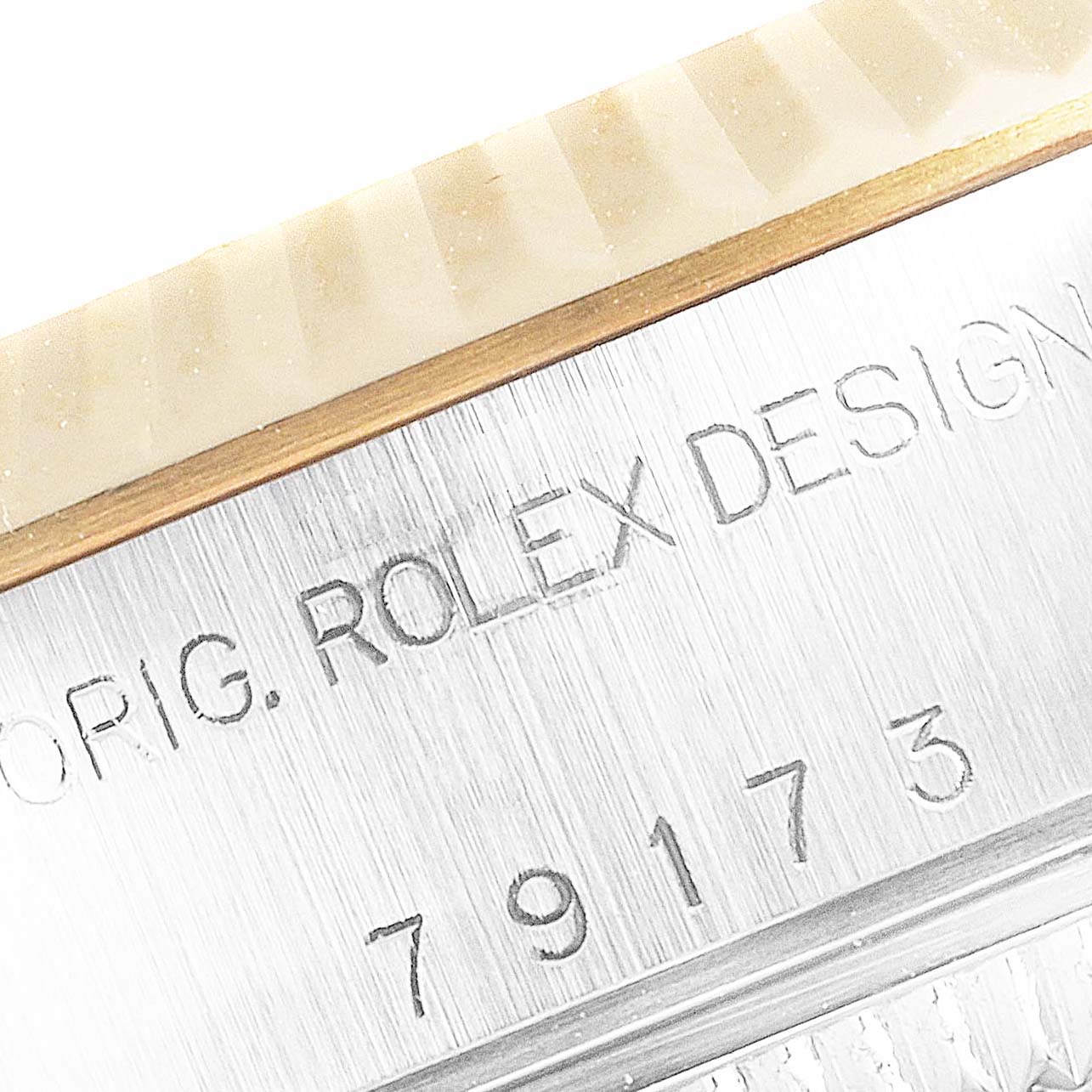 The image shows a close-up of the engraved details on the case of a Rolex Datejust 79173 Women
s Steel and Gold (two tone) Mother of Pearl Dial 79173 Women
s Steel and Gold (two tone) Mother of Pearl Dial watch, displaying "ROLEX DESIGN."