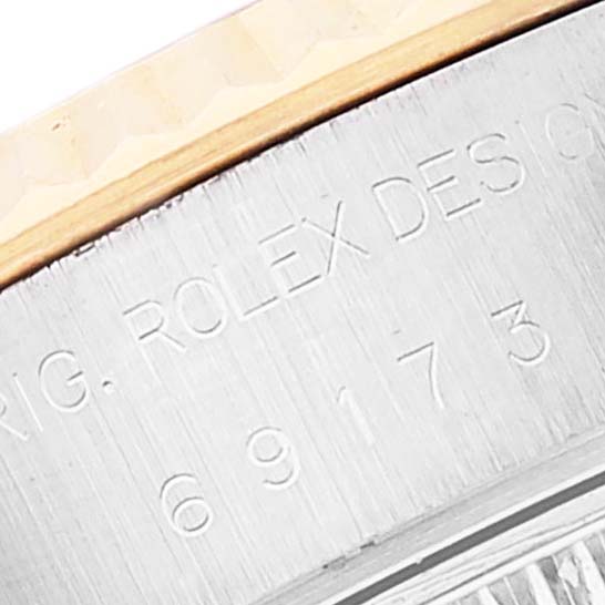 The image shows a close-up of the Rolex Datejust 69173 Women's Steel and Gold (two tone) Blue Dial 69173 Women's Steel and Gold (two tone) Blue Dial watch case, highlighting the engraved model and serial numbers.