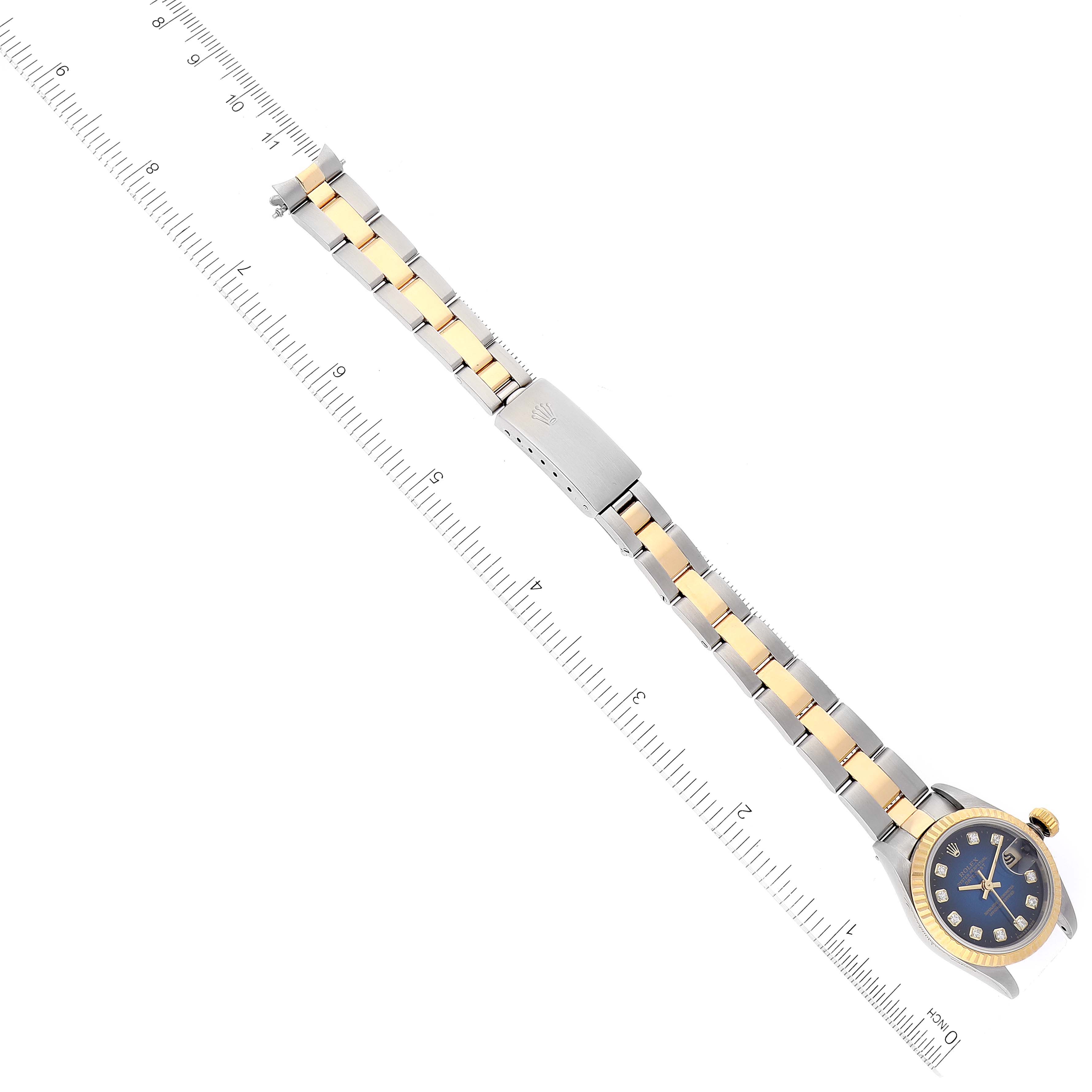 This image shows a top-down view of a Rolex Datejust 69173 Women's Steel and Gold (two tone) Blue Dial 69173 Women's Steel and Gold (two tone) Blue Dial watch with its bracelet aligned next to a ruler.