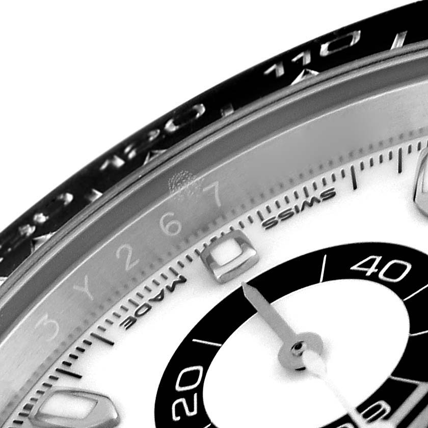 This close-up image of the Rolex Daytona 116500LN Men's Stainless Steel White Dial 116500LN Men's Stainless Steel White Dial model shows the bezel, part of the dial, and a hand.