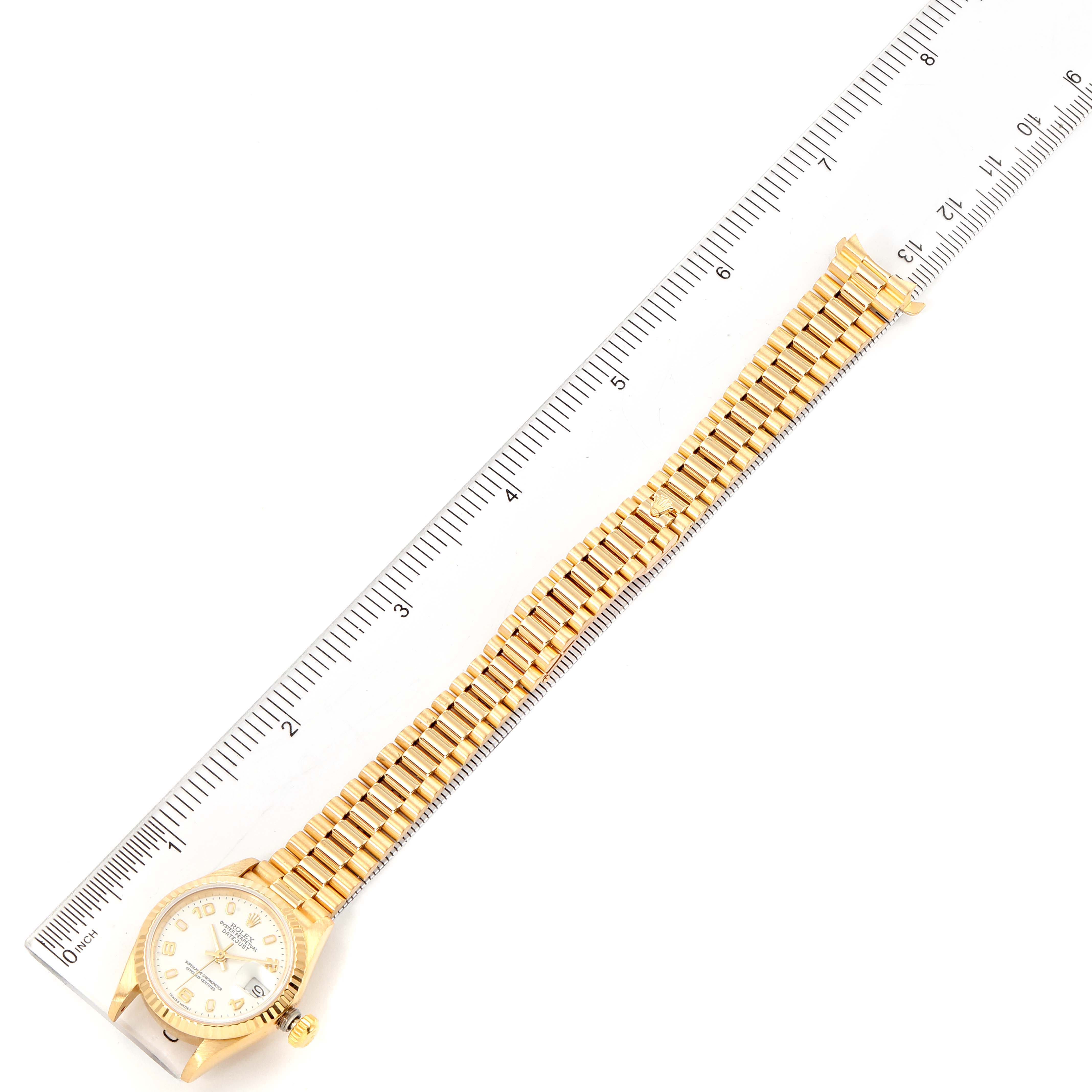 The Rolex President 69178 Women's Yellow Gold White Dial 69178 Women's Yellow Gold White Dial model watch is shown face-up, with the full band extended next to a ruler for scale.