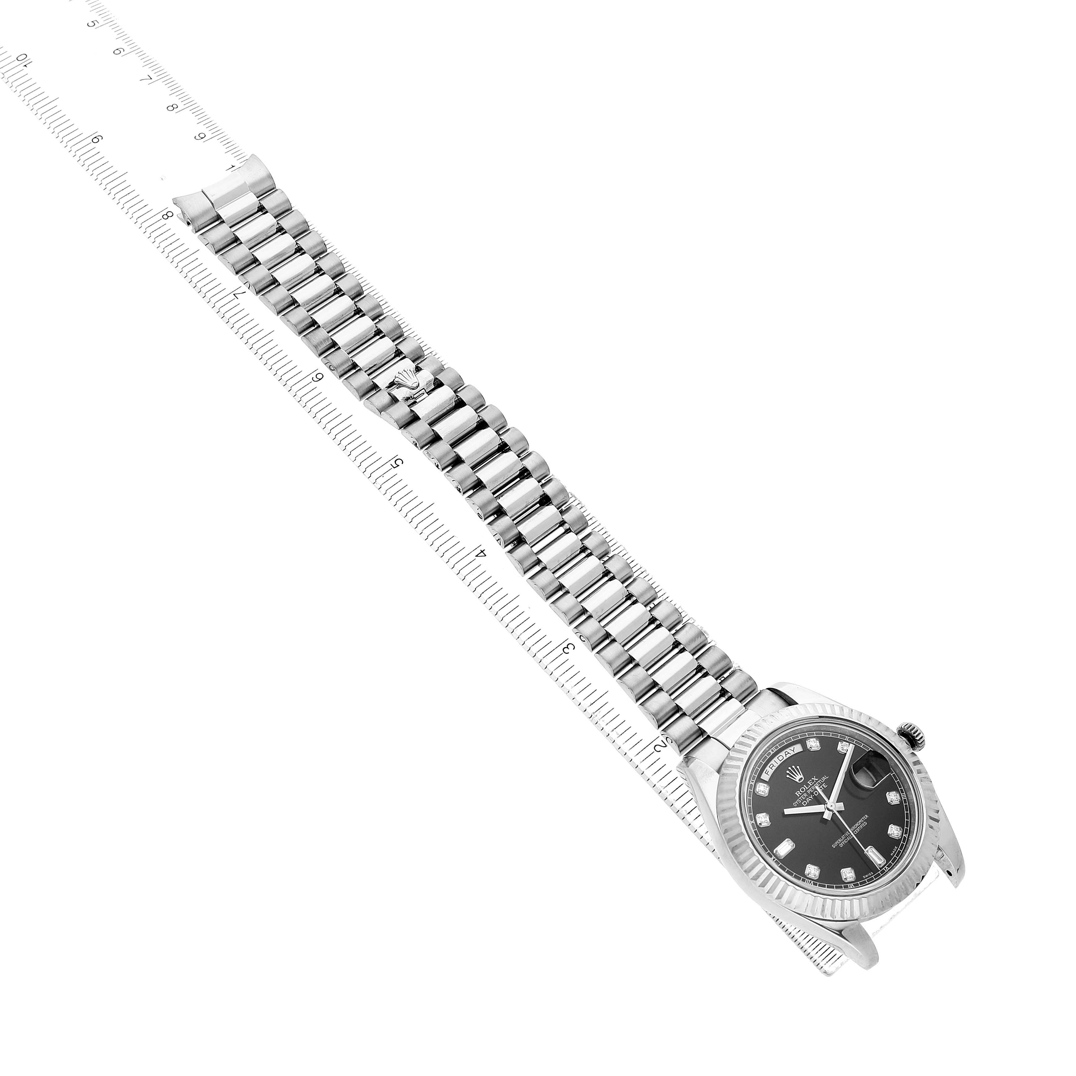 The image shows a Rolex President 218239 Men's White Gold Black Dial watch angled diagonally, displaying its bracelet, case, and face with visible hour markers.