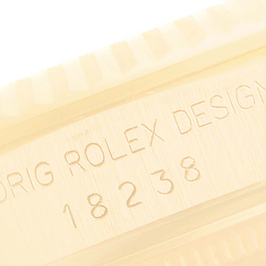 The image shows a close-up of the side engraving on a Rolex President 18238 Men's Yellow Gold Champagne Dial 18238 Men's Yellow Gold Champagne Dial model watch, including the serial number and design code.