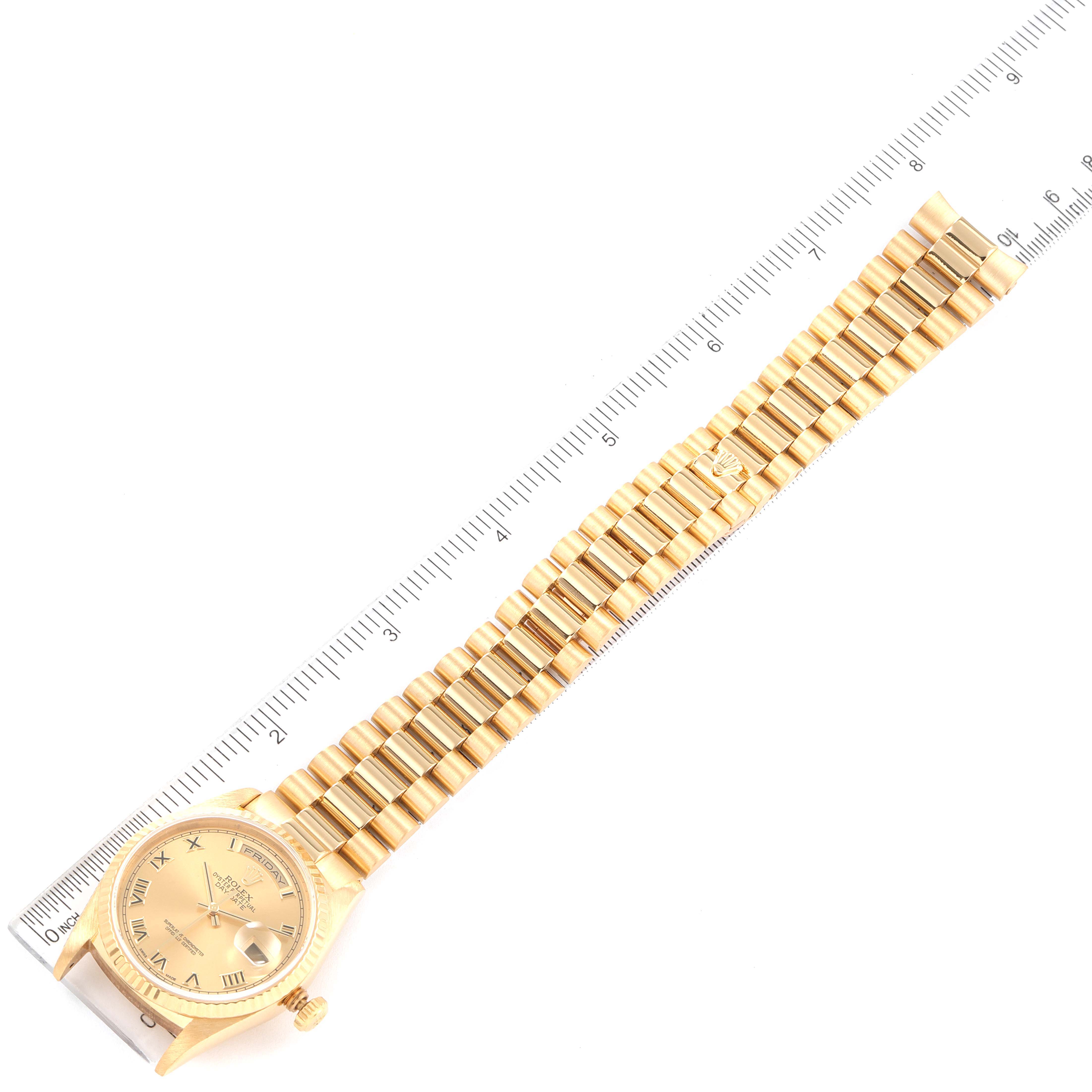 The Rolex President 18238 Men's Yellow Gold Champagne Dial 18238 Men's Yellow Gold Champagne Dial model watch is shown from a top-down angle along with its full bracelet and a ruler for measurement.