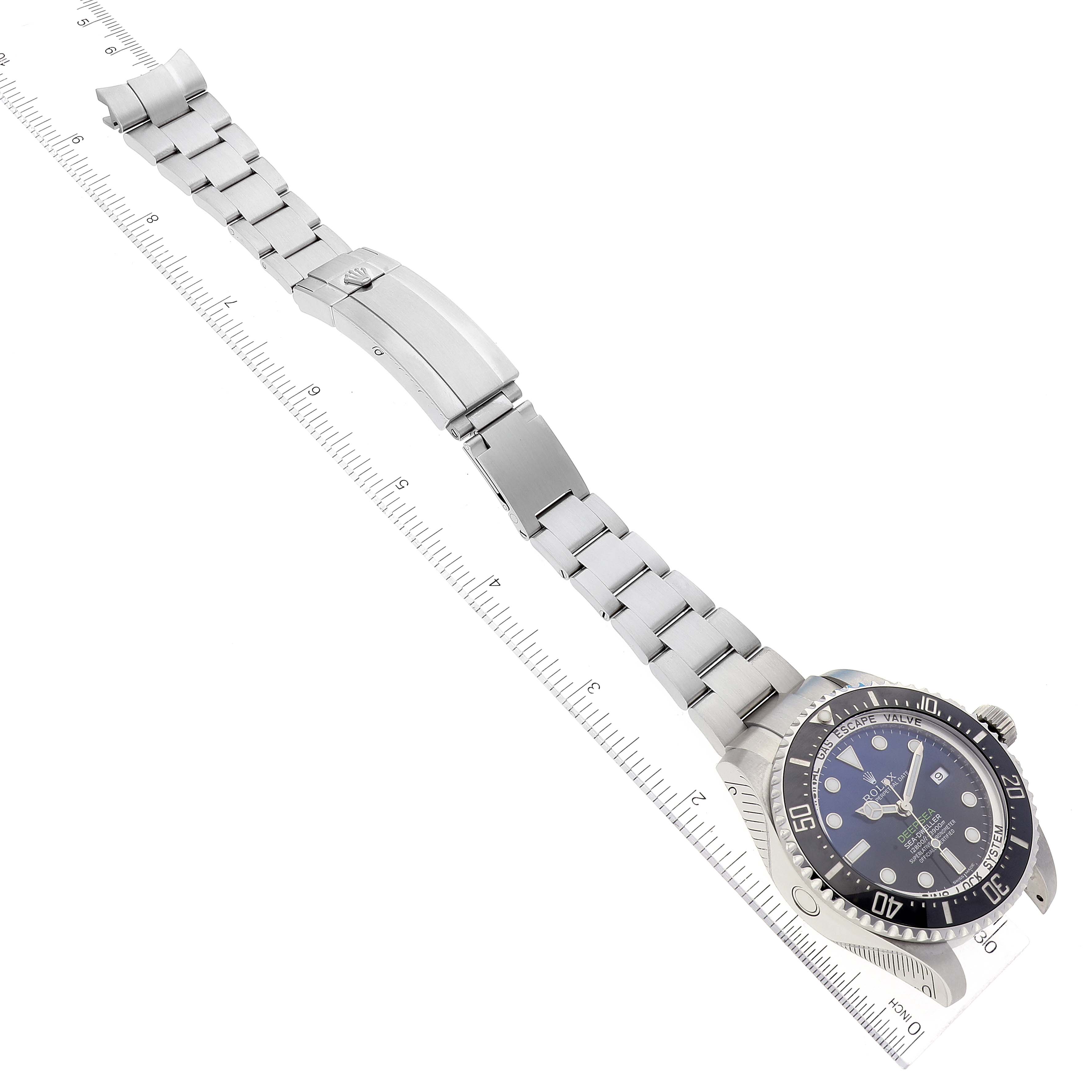 The image shows the Rolex Sea-Dweller 116660 Men's Stainless Steel Blue Dial 116660 Men's Stainless Steel Blue Dial watch laid flat, displaying the face, metal bracelet, and clasp, with a ruler for scale.