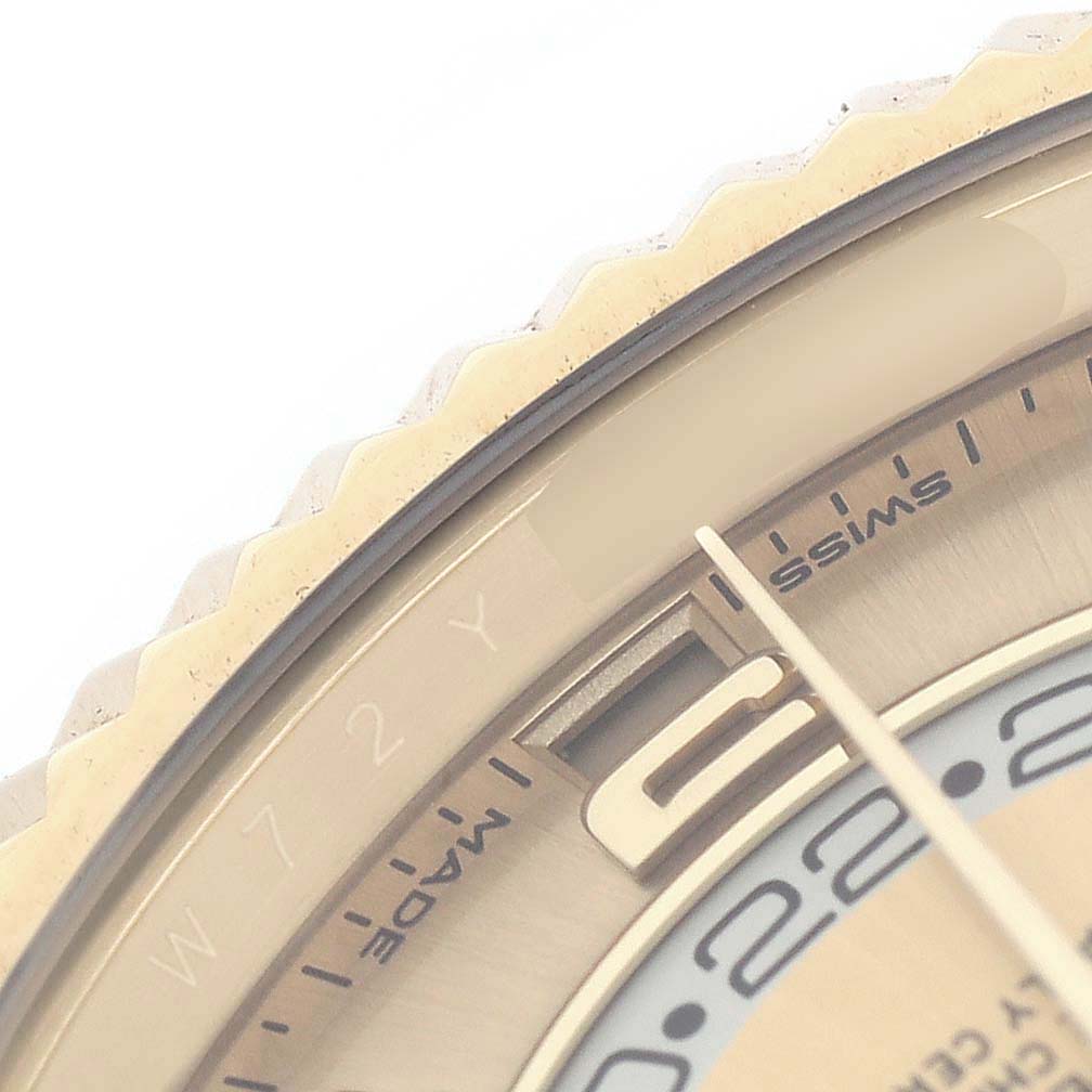 This close-up image shows the edge of a Rolex Sky-Dweller 326938 Men's Yellow Gold Champagne Dial watch, focusing on the bezel and part of the dial.