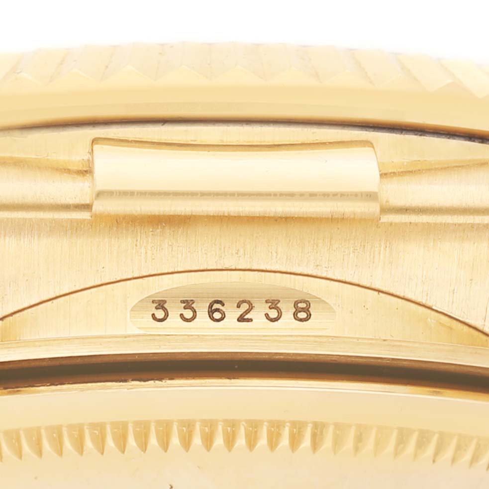The image shows a close-up of the side of a Rolex Sky-Dweller 336238 Men's Yellow Gold Champagne Dial, focusing on part of the bezel and serial number.