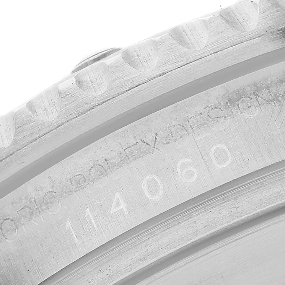 The image shows a close-up of the bezel and engraved side of a Rolex Submariner 114060 Men's Stainless Steel Black Dial watch case.