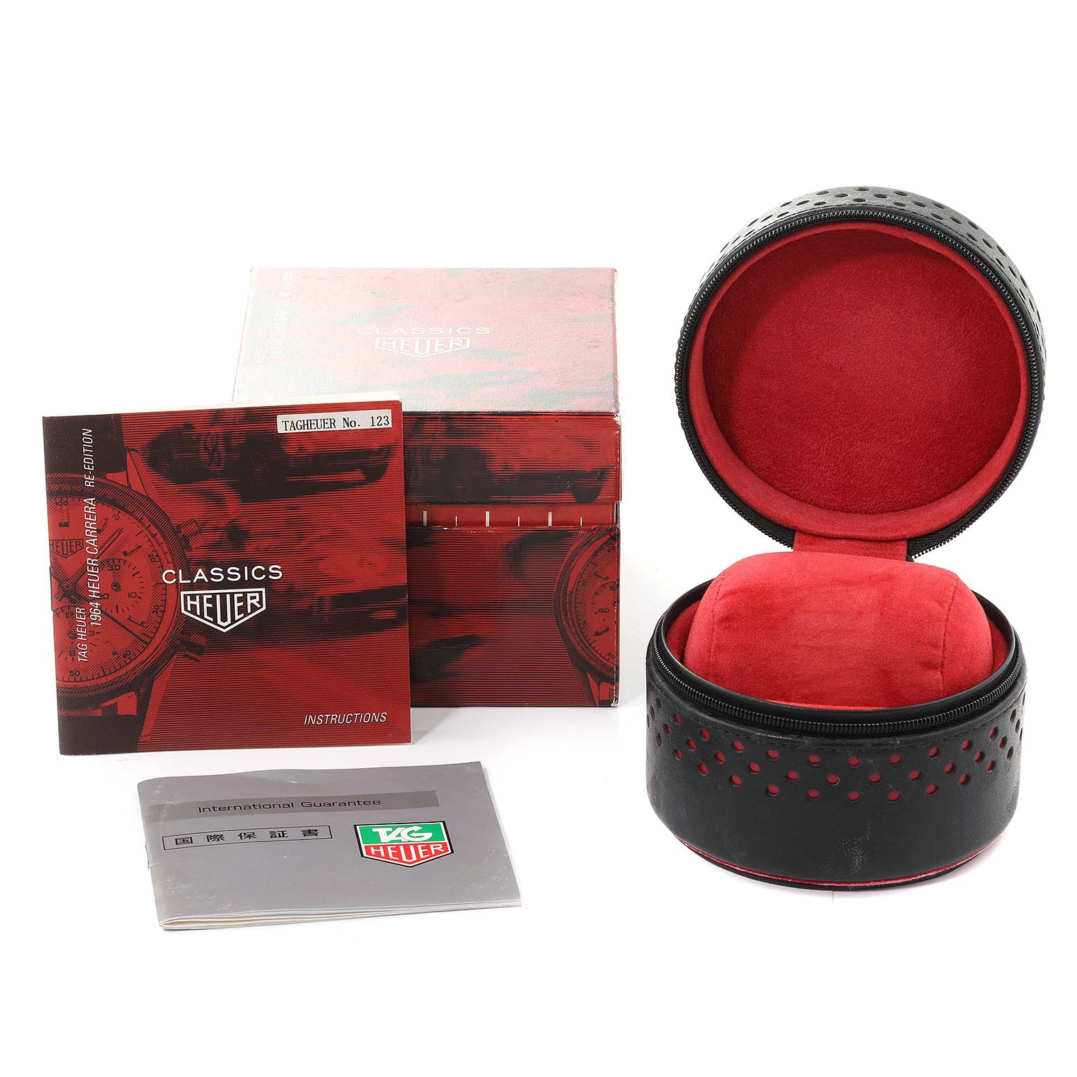 The image shows accessories for the Carrera model by Tag Heuer, including a watch box, manuals, and a watch case.