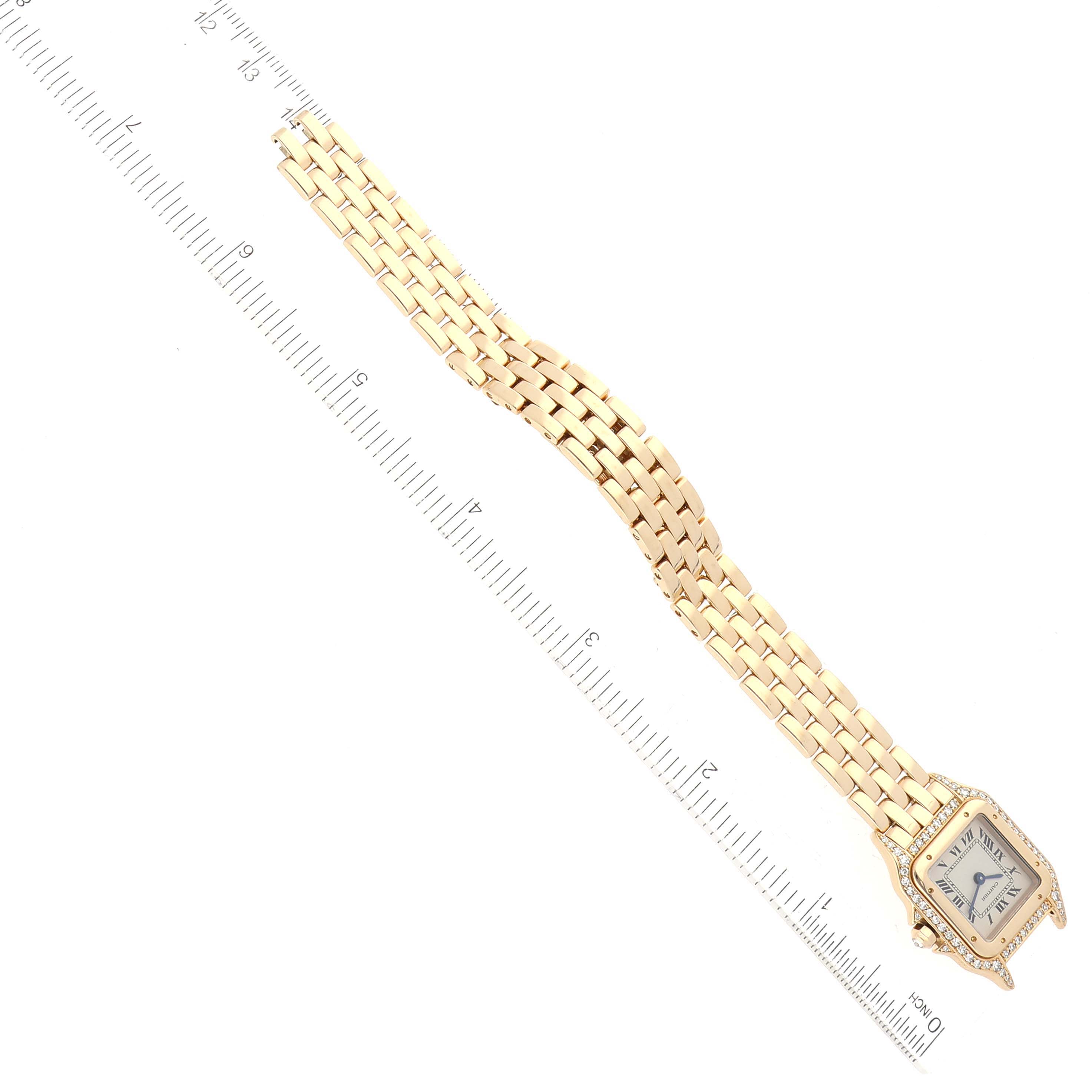 The Cartier Panthere 17439 Women's Yellow Gold Silver Dial 17439 Women's Yellow Gold Silver Dial watch is shown at a top-down angle, featuring its face and gold bracelet band, with a ruler for scale.
