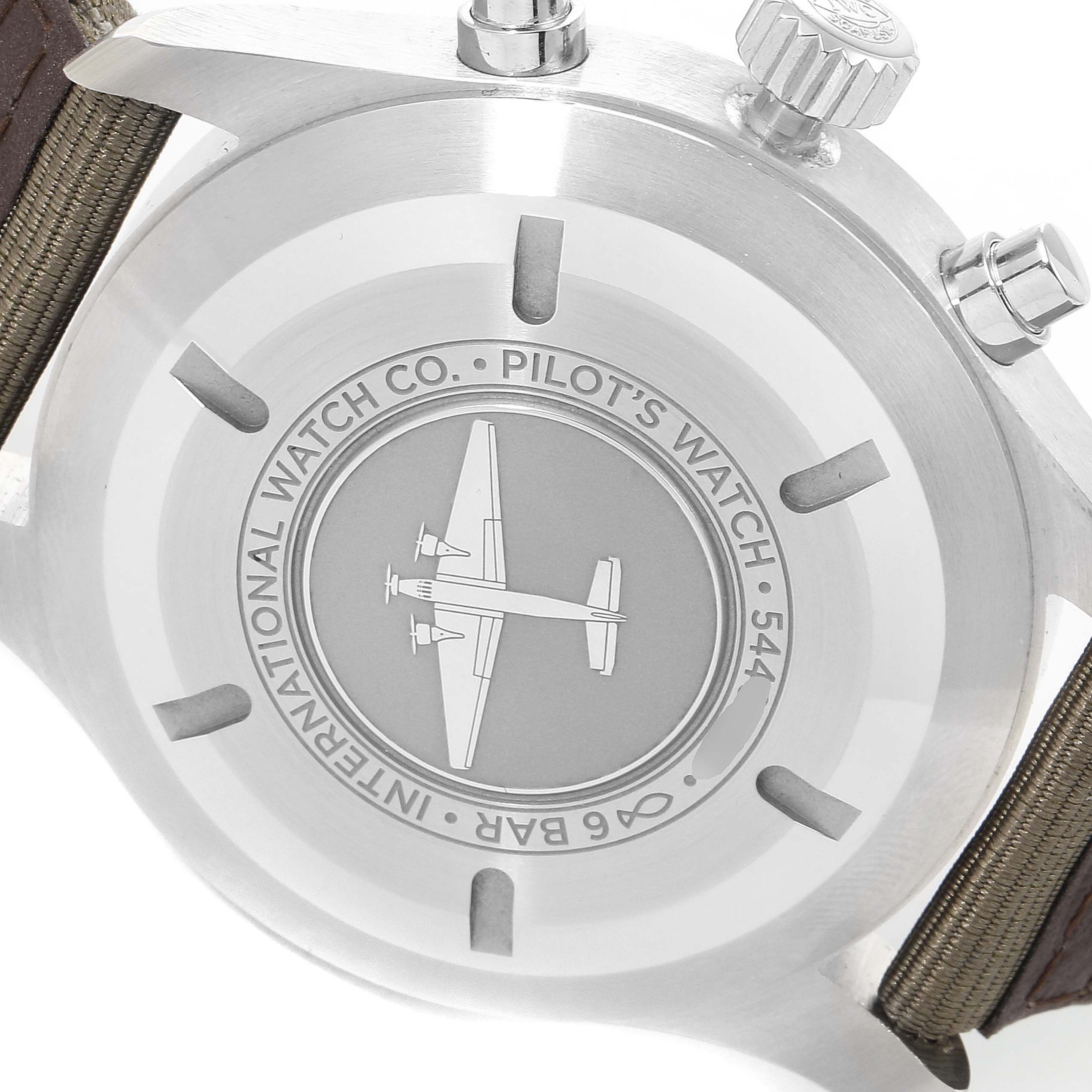 The image shows the back case of the Pilot model watch by IWC, featuring an engrained airplane image and text.