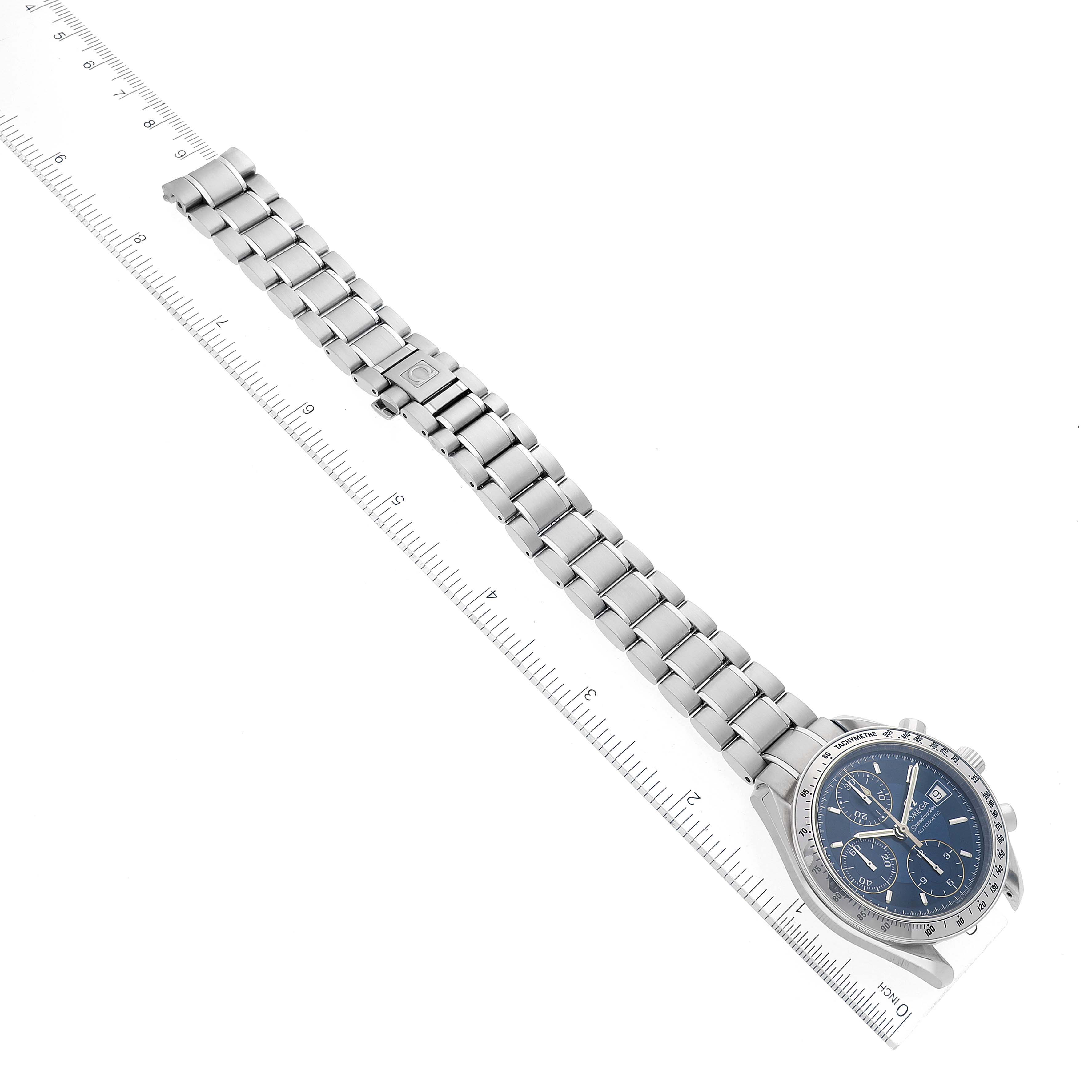 The image shows the Omega Speedmaster 3513.80.00 Men's Stainless Steel Blue Dial 3513.80.00 Men's Stainless Steel Blue Dial watch and its metal bracelet laid flat against a ruler, displaying the entire length.
