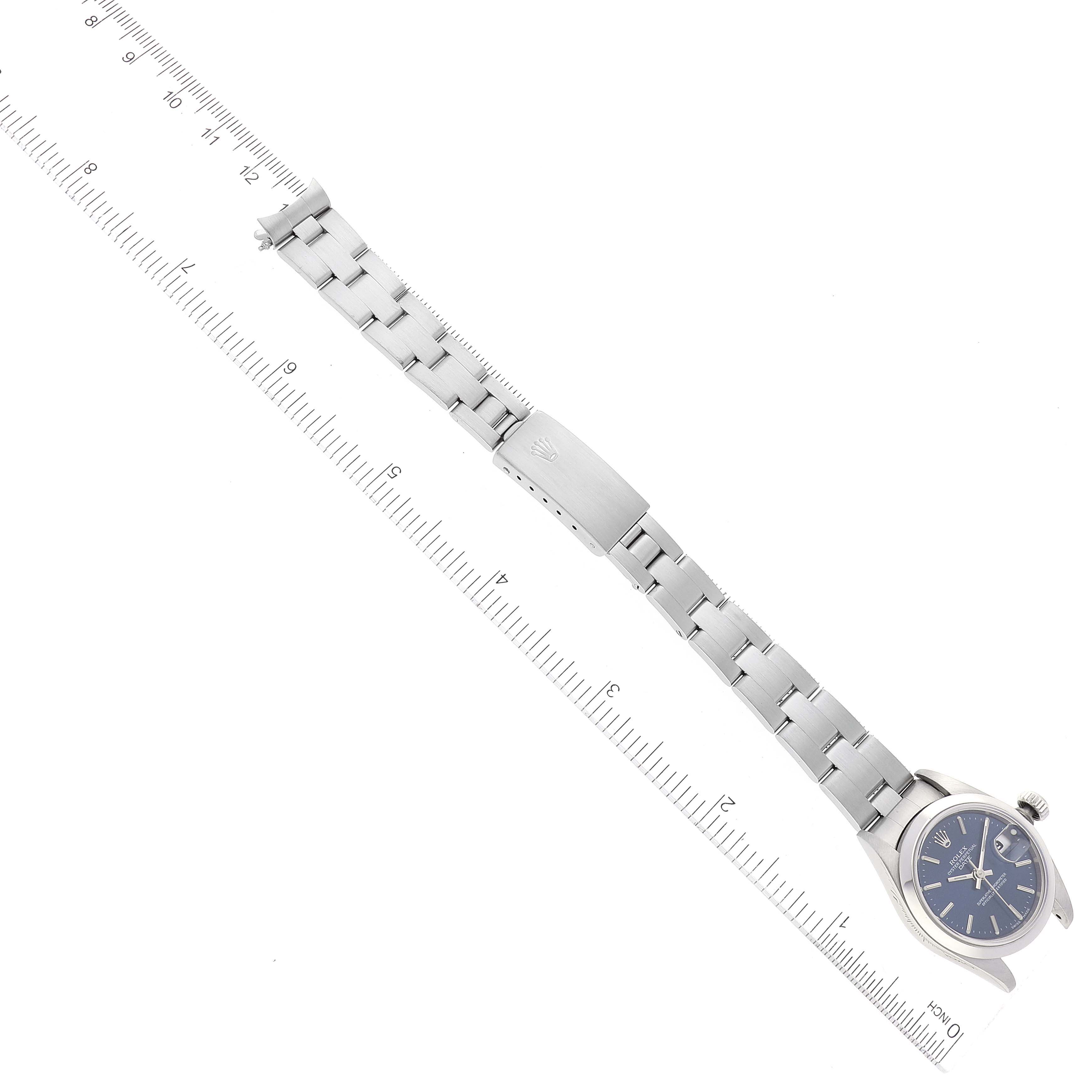 The image shows a Rolex Datejust 69160 Women's Stainless Steel Blue Dial 69160 Women's Stainless Steel Blue Dial watch laid flat with its bracelet extended beside a ruler for size reference.