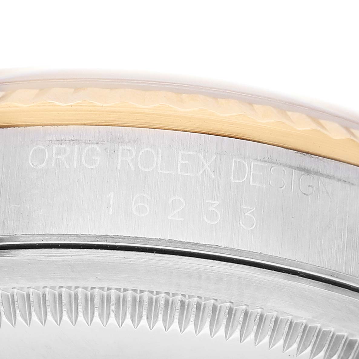 The image shows a close-up of the side of a Rolex Datejust 16233 Men's Steel and Gold (two tone) Champagne Dial case, highlighting the bezel and engraved design numbers.