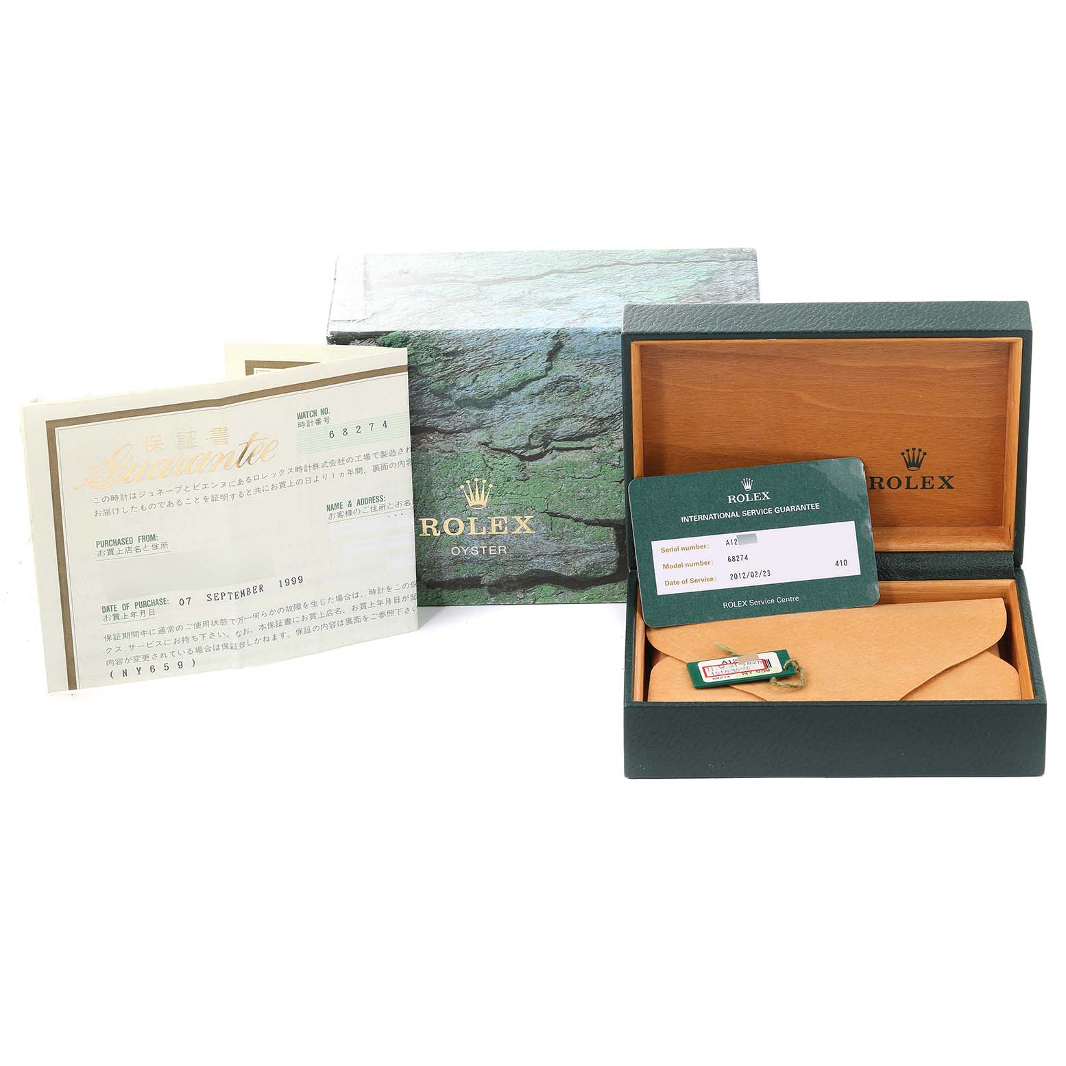 The image shows the packaging, warranty card, and paperwork for a mid-size Rolex watch model.