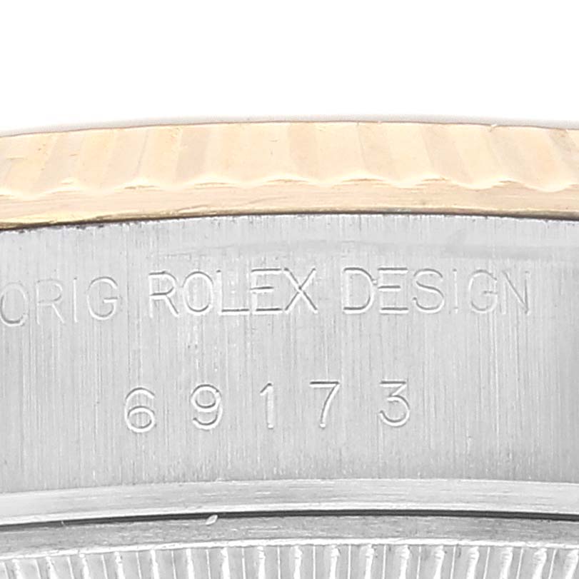 The image shows a close-up of the side view of a Rolex Datejust 69173 Women's Steel and Gold (two tone) Champagne Dial 69173 Women's Steel and Gold (two tone) Champagne Dial watch, displaying the "ORIG ROLEX DESIGN" engraving and model number 69173.