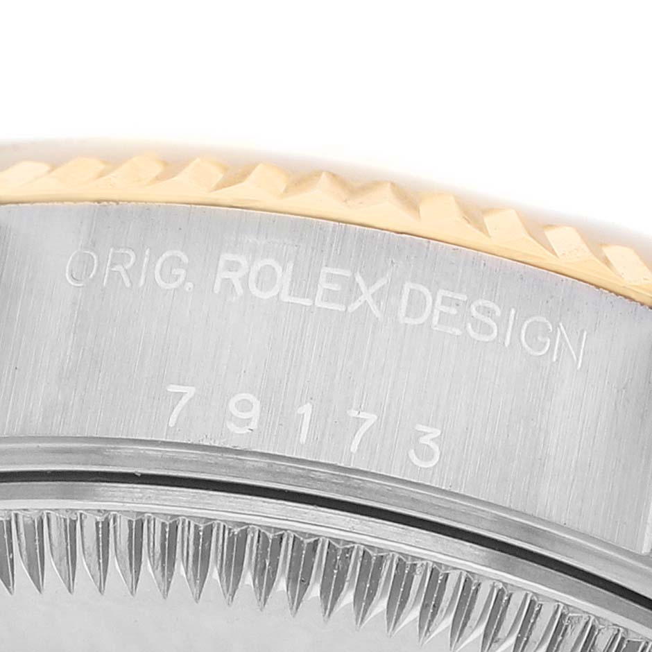 The image shows a close-up of the side of a Rolex Datejust 79173 Women's Steel and Gold (two tone) White Dial's case, focusing on the engraved model number and fluted bezel.